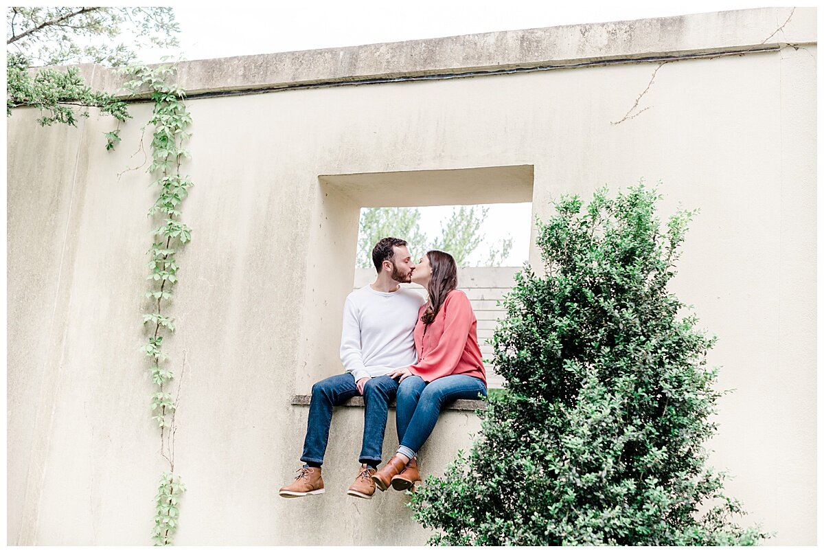 engaged couple sitting in a pretty window in a garden