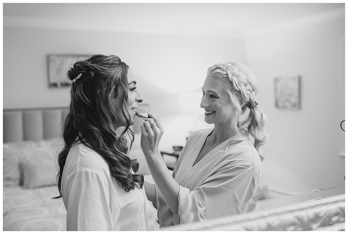 maid of honor putting lipstick on bride