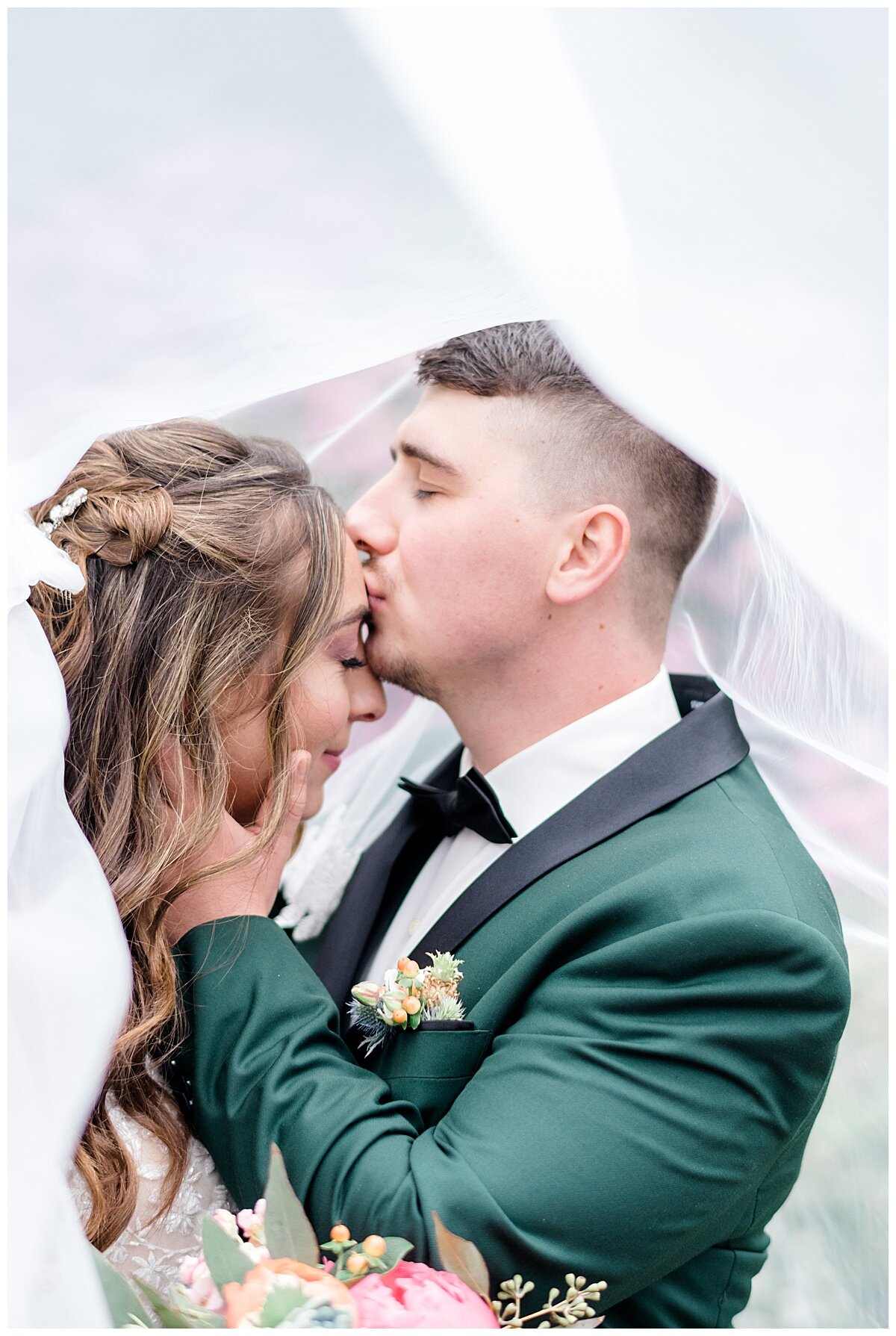 groom kissing bride on her head