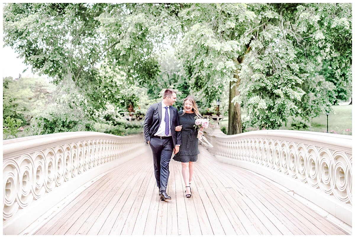 engaged couple on bow bridge central park walking arm and arm