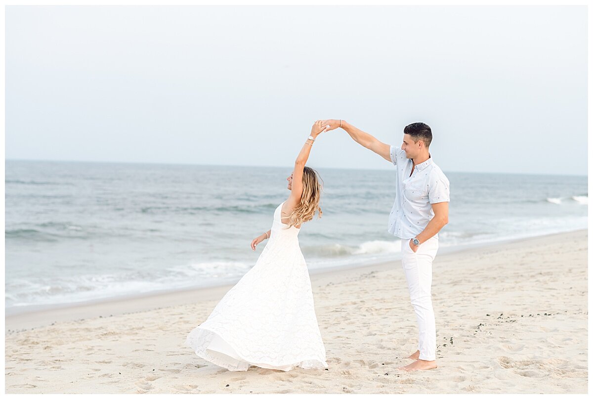 engaged couple dancing on the beach