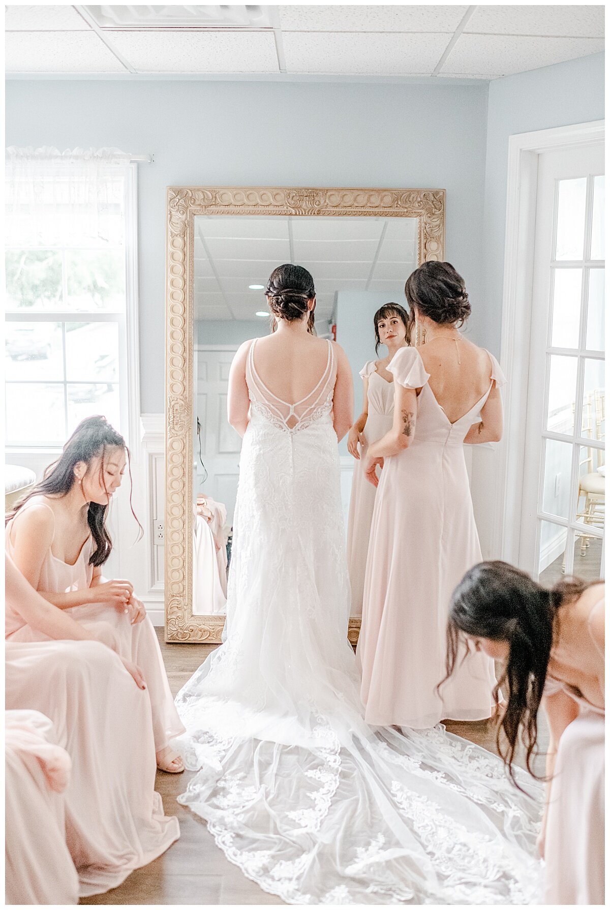 bride and maid of honor getting dressed in bridal suite