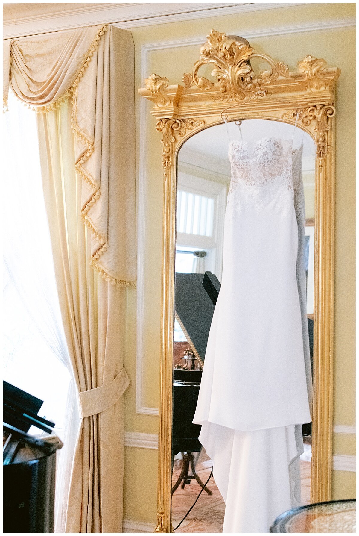 wedding gown hanging on a gold mirror