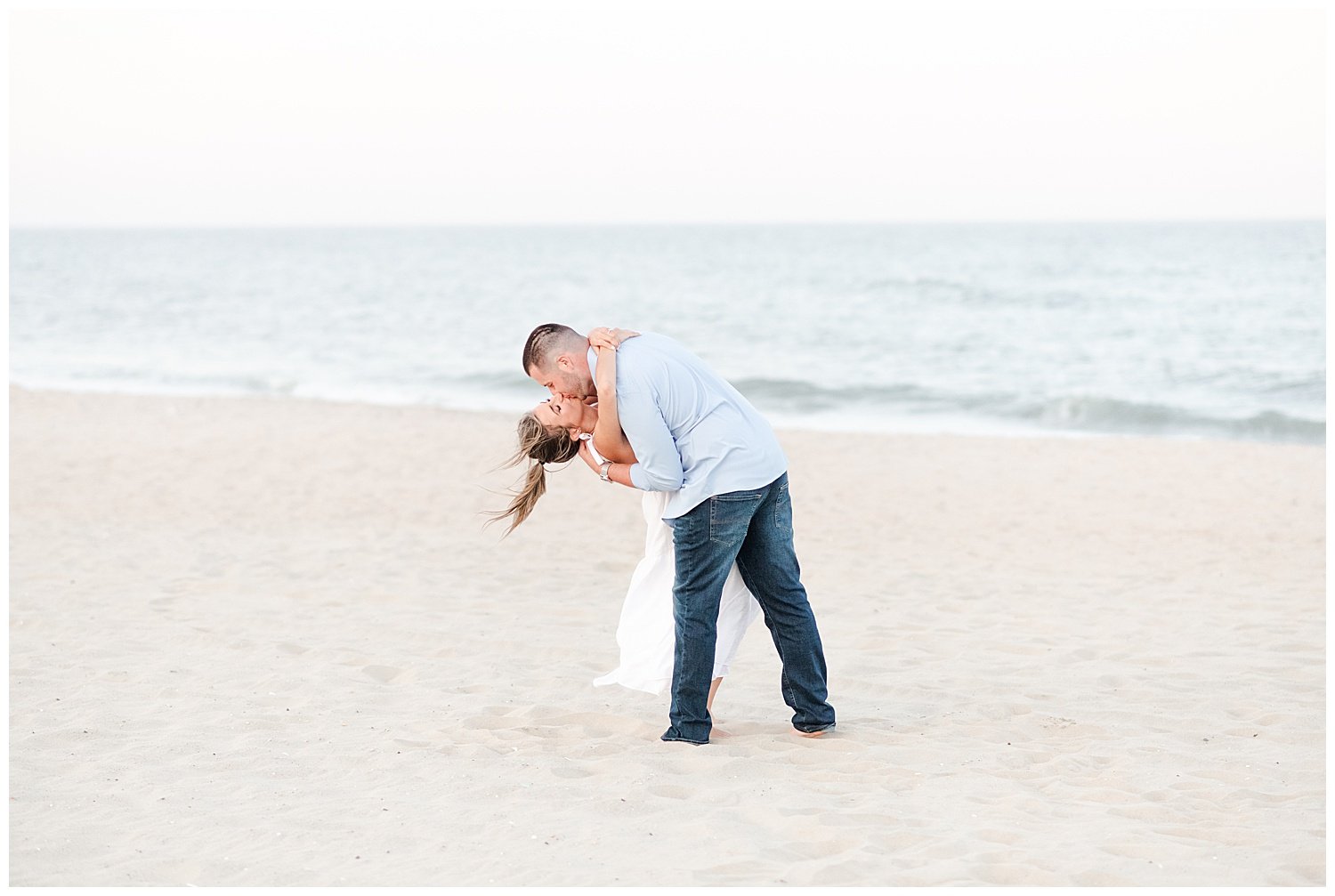 engaged couple kissing on the beach