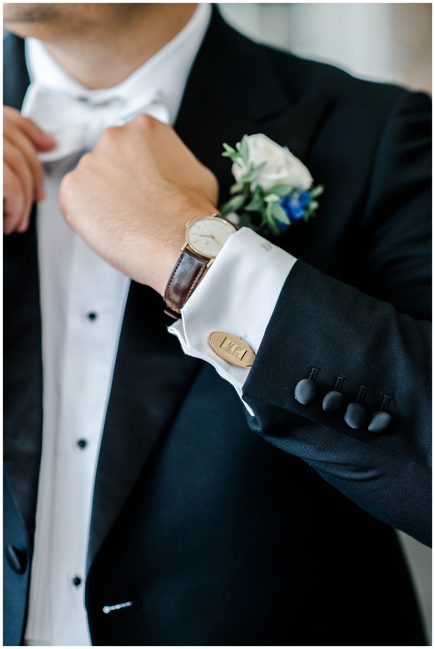 groom tying his bow tie on wedding day