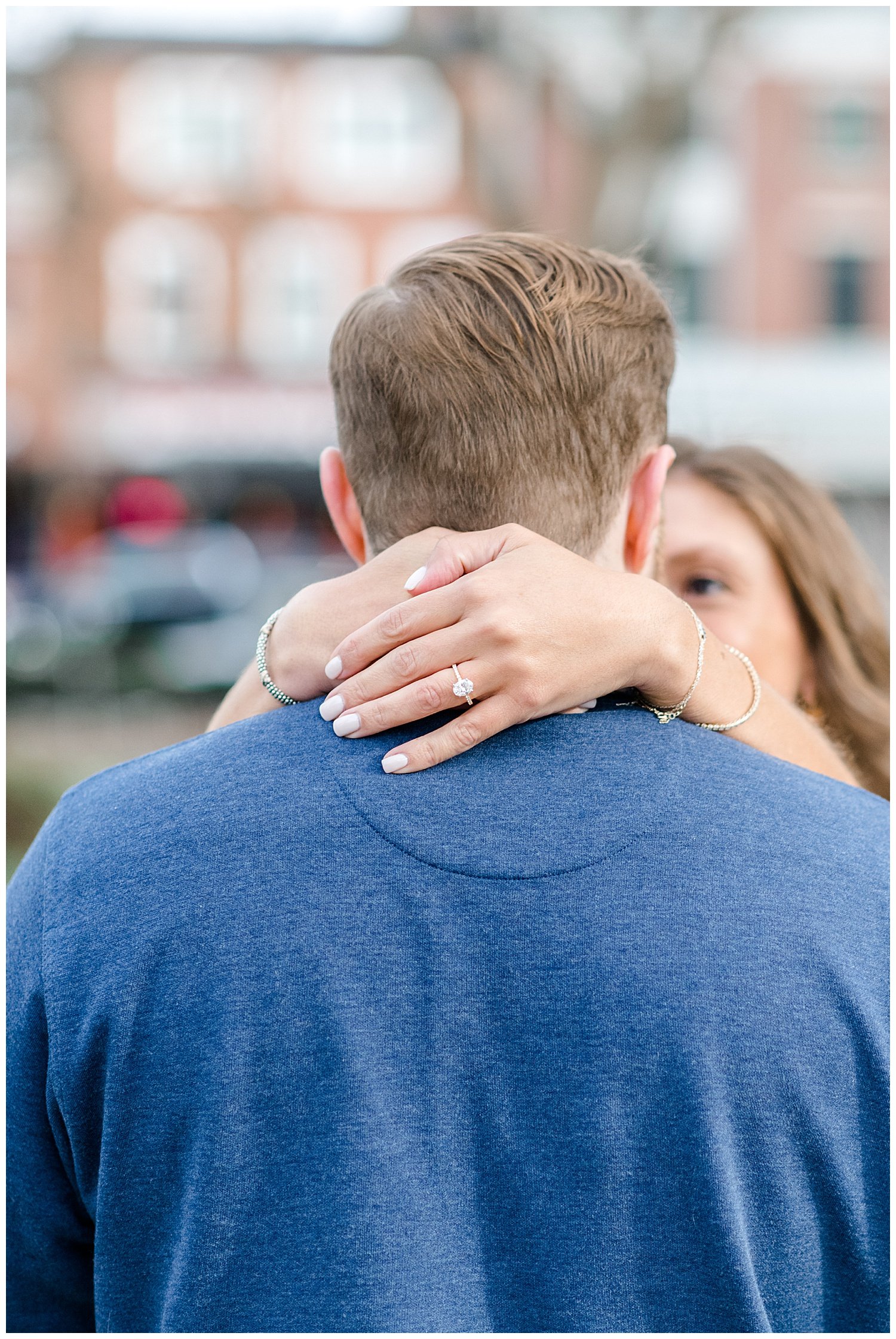 bride showing her engagement ring hugging fiance