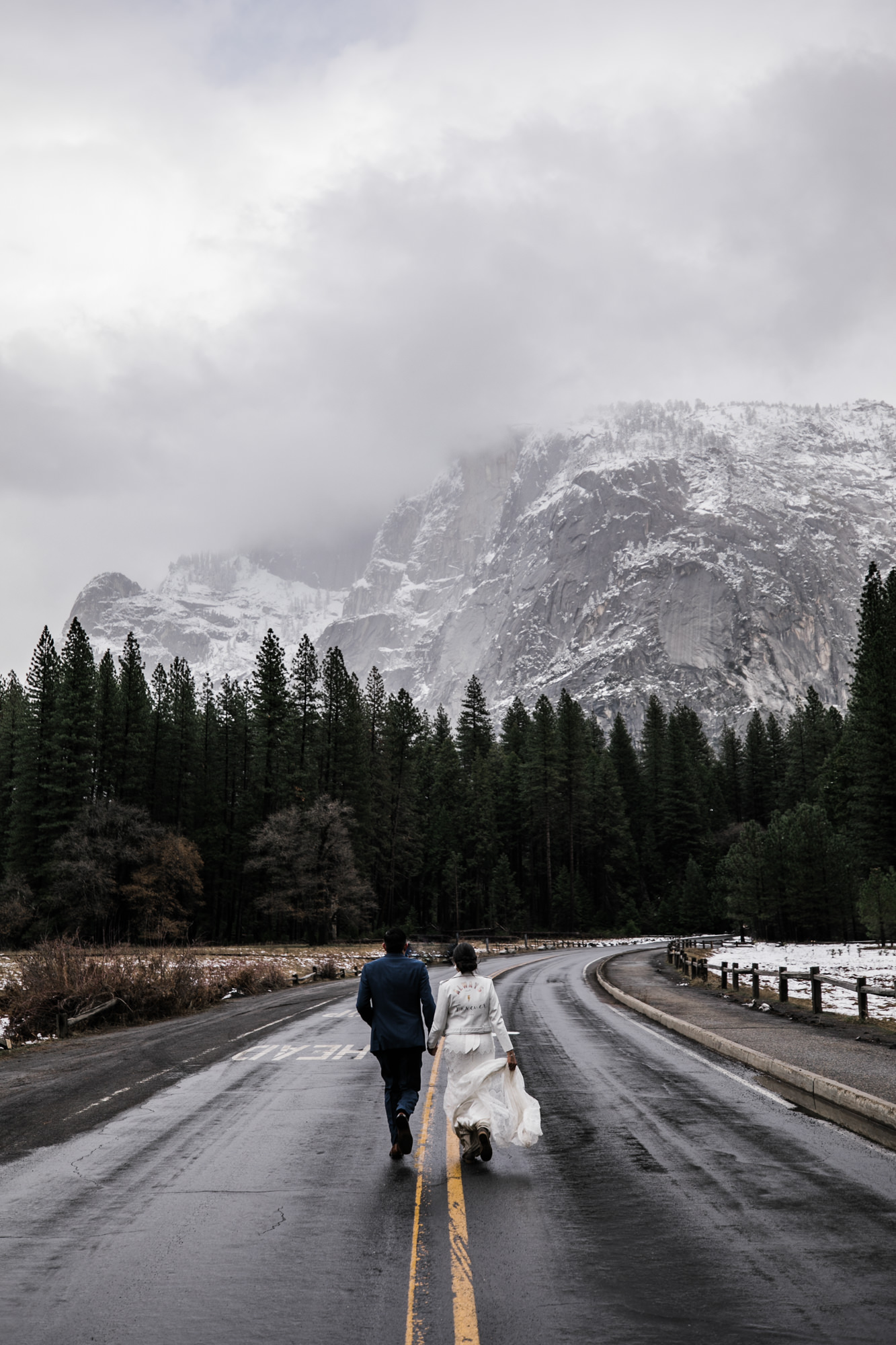 bride and groom running toward half dome in yosemite national park