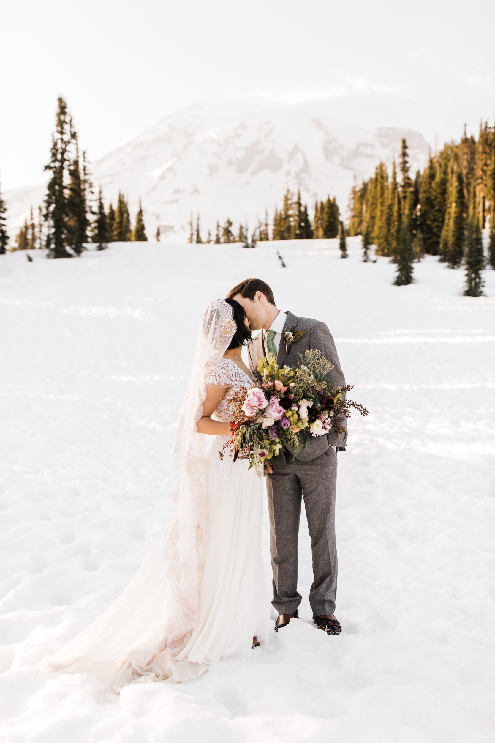 intimate wedding and reception in mount rainier national park | a frame cabin elopement first look | woodsy small reception in washington | snowy wedding portraits | elopement in the mountains