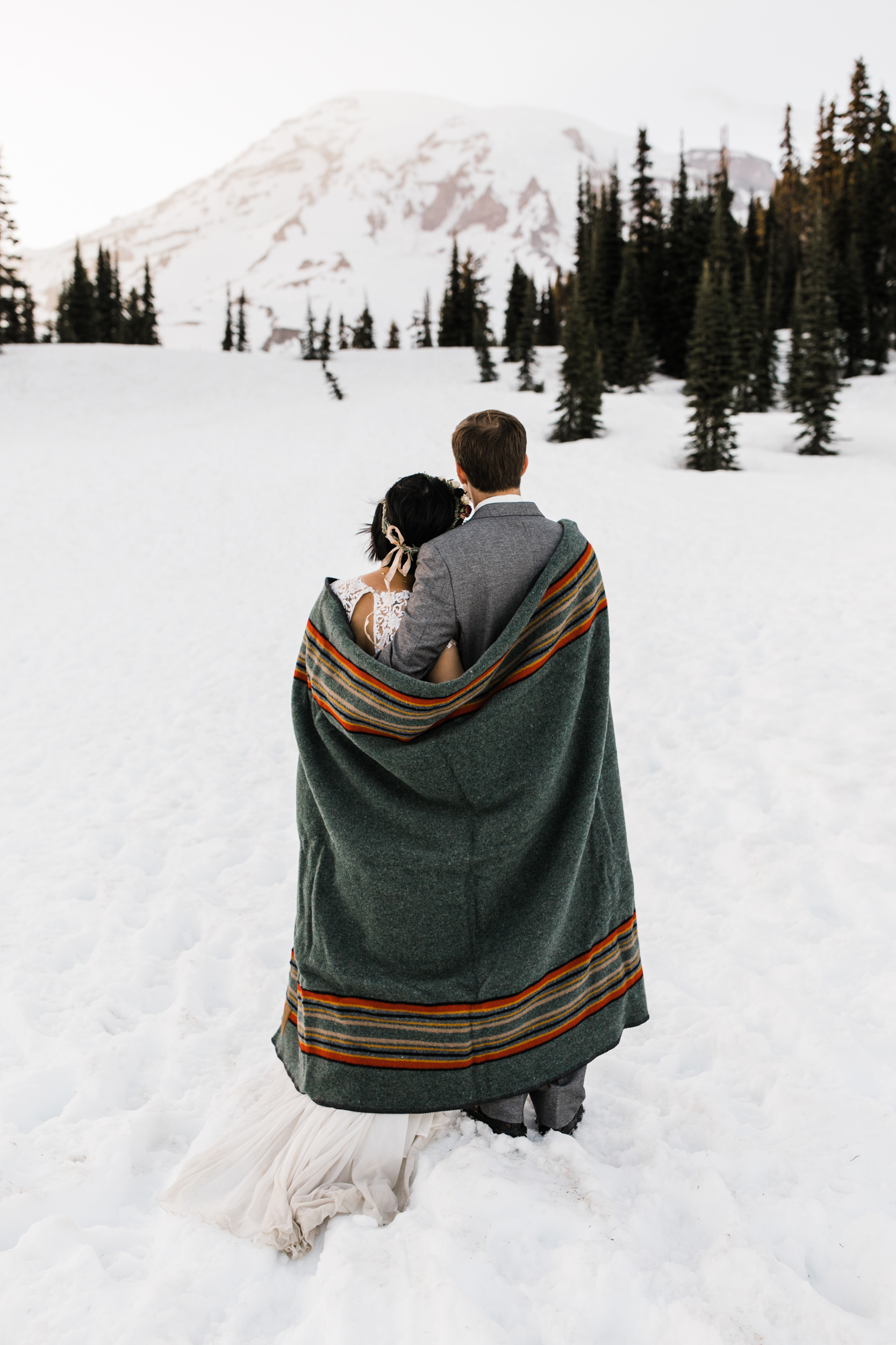 intimate wedding and reception in mount rainier national park | a frame cabin elopement first look | woodsy small reception in washington | snowy wedding portraits | elopement in the mountains