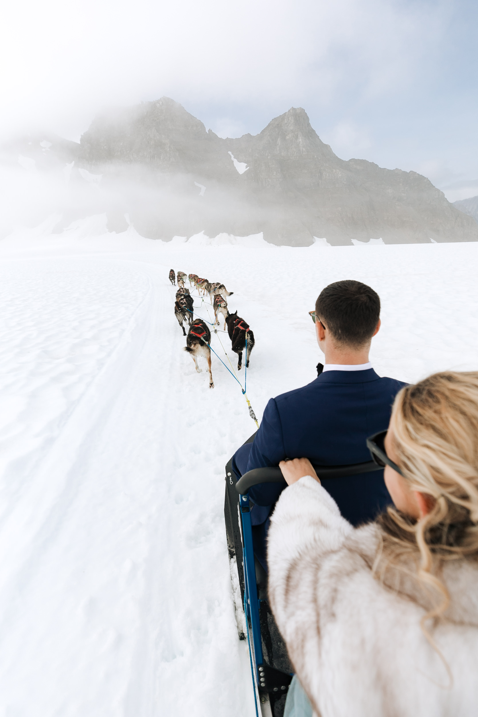 alaska destination wedding in seward | helicopter tour, dog sledding on a glacier | wedding day puppies | the hearnes adventure elopement photography