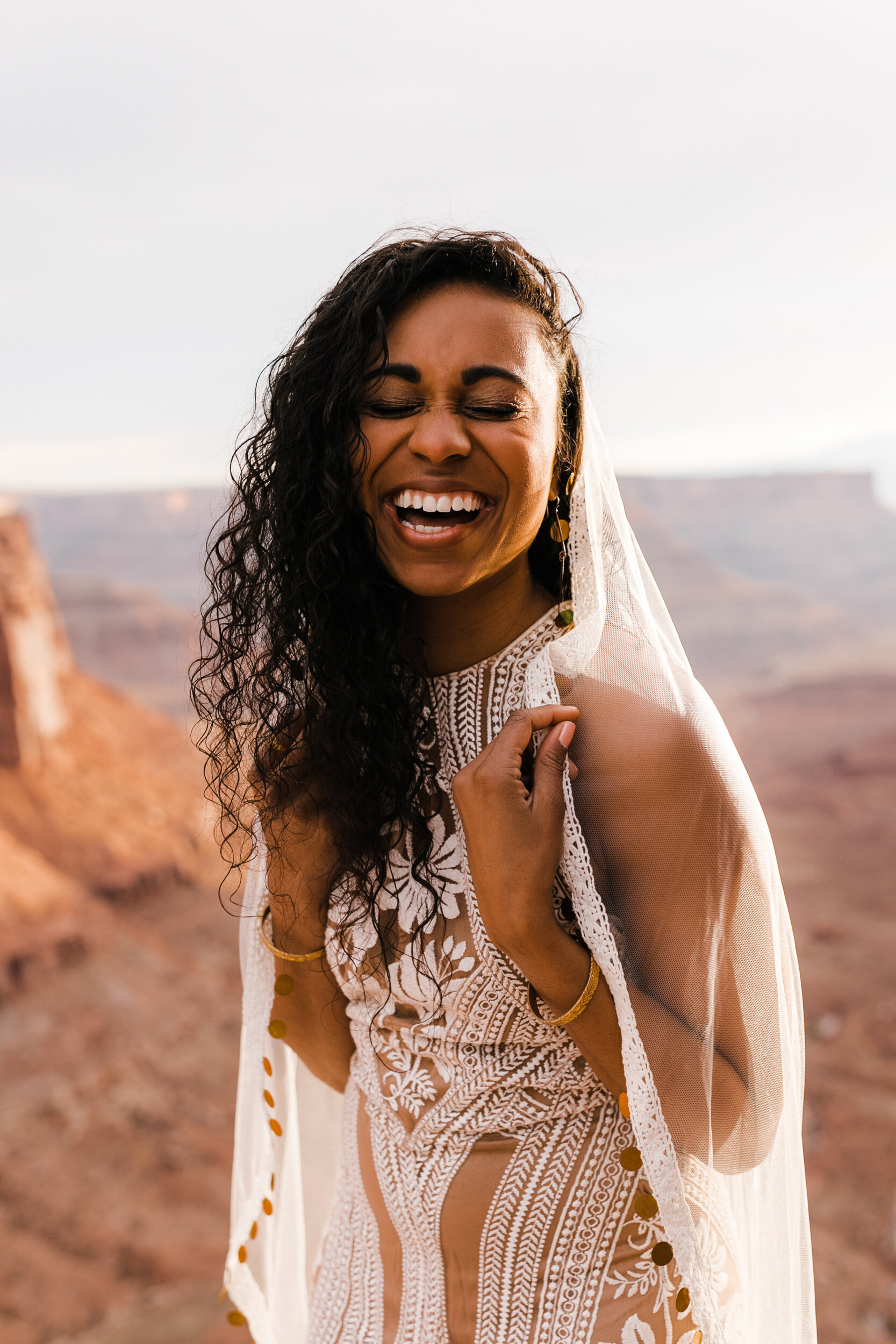This Moab Elopement in Canyonlands National Park is major desert wedding inspiration! A surprise proposal at sunrise and Rue De Seine East Gown and Gold Coin Veil by The Hearnes Adventure Photography