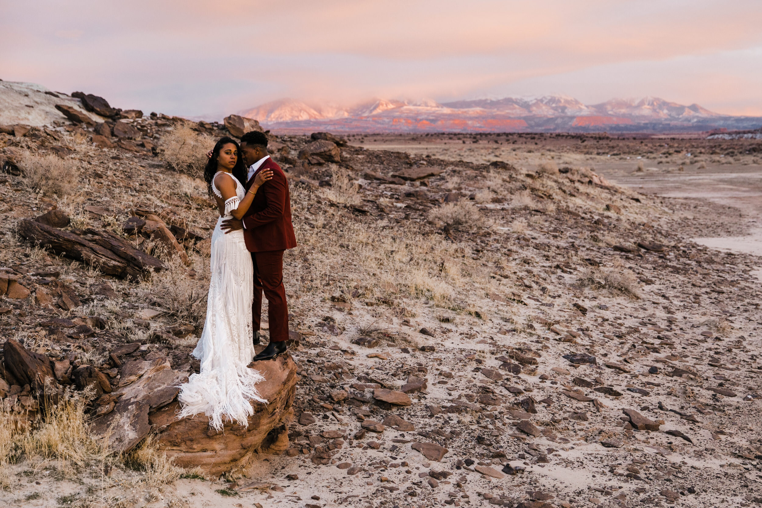 Moab Elopement Photographer | The Hearnes | Rue de Seine Dallas Gown | Bohemian Bride Fringe Wedding Dress &amp; Groom’s Burgundy Suit