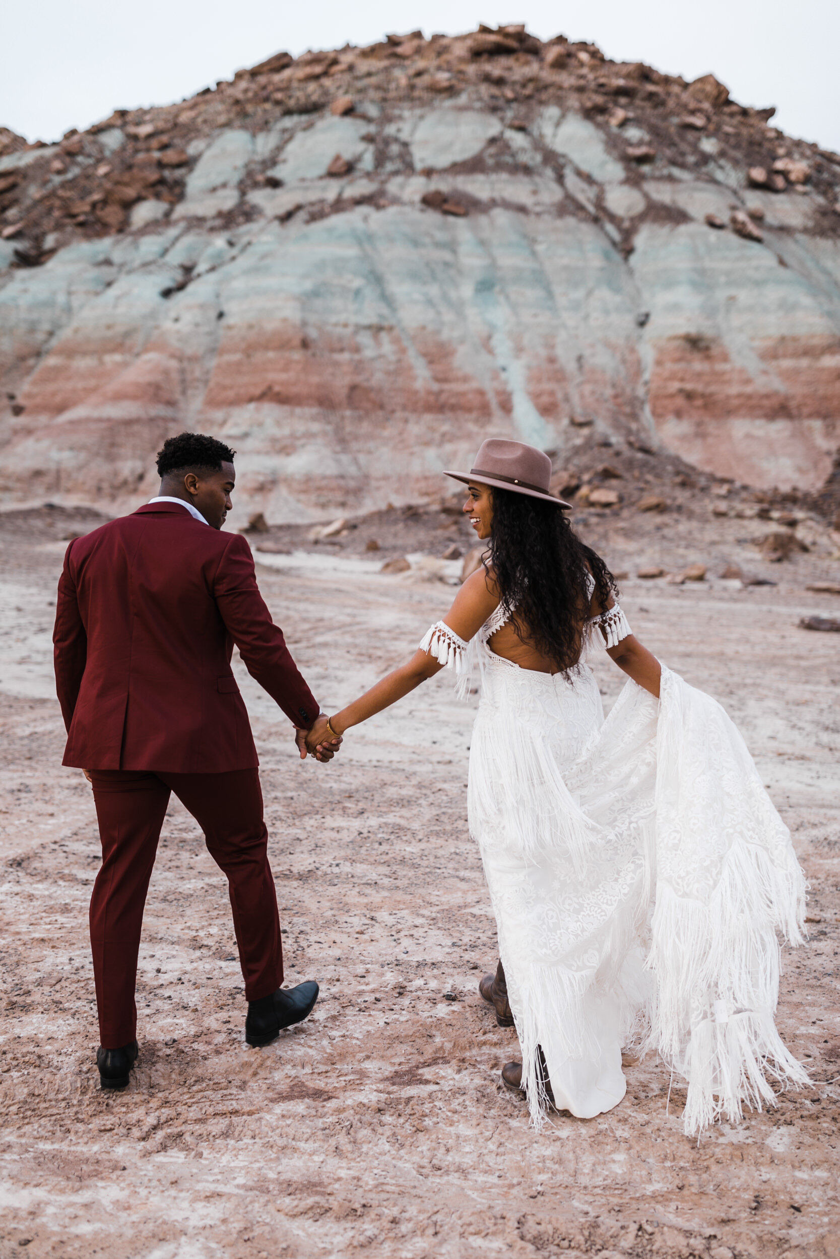 Moab Elopement Photographer | The Hearnes | Rue de Seine Dallas Gown | Bohemian Bride Fringe Wedding Dress &amp; Groom’s Burgundy Suit