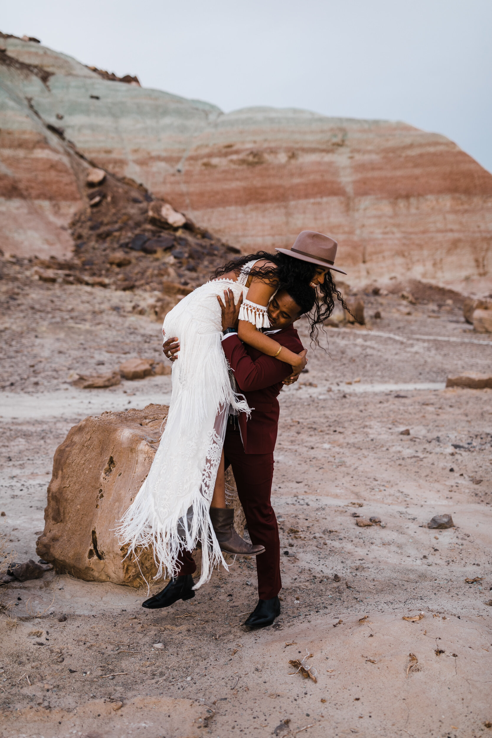 Moab Elopement Photographer | The Hearnes | Rue de Seine Dallas Gown | Bohemian Bride Fringe Wedding Dress &amp; Groom’s Burgundy Suit