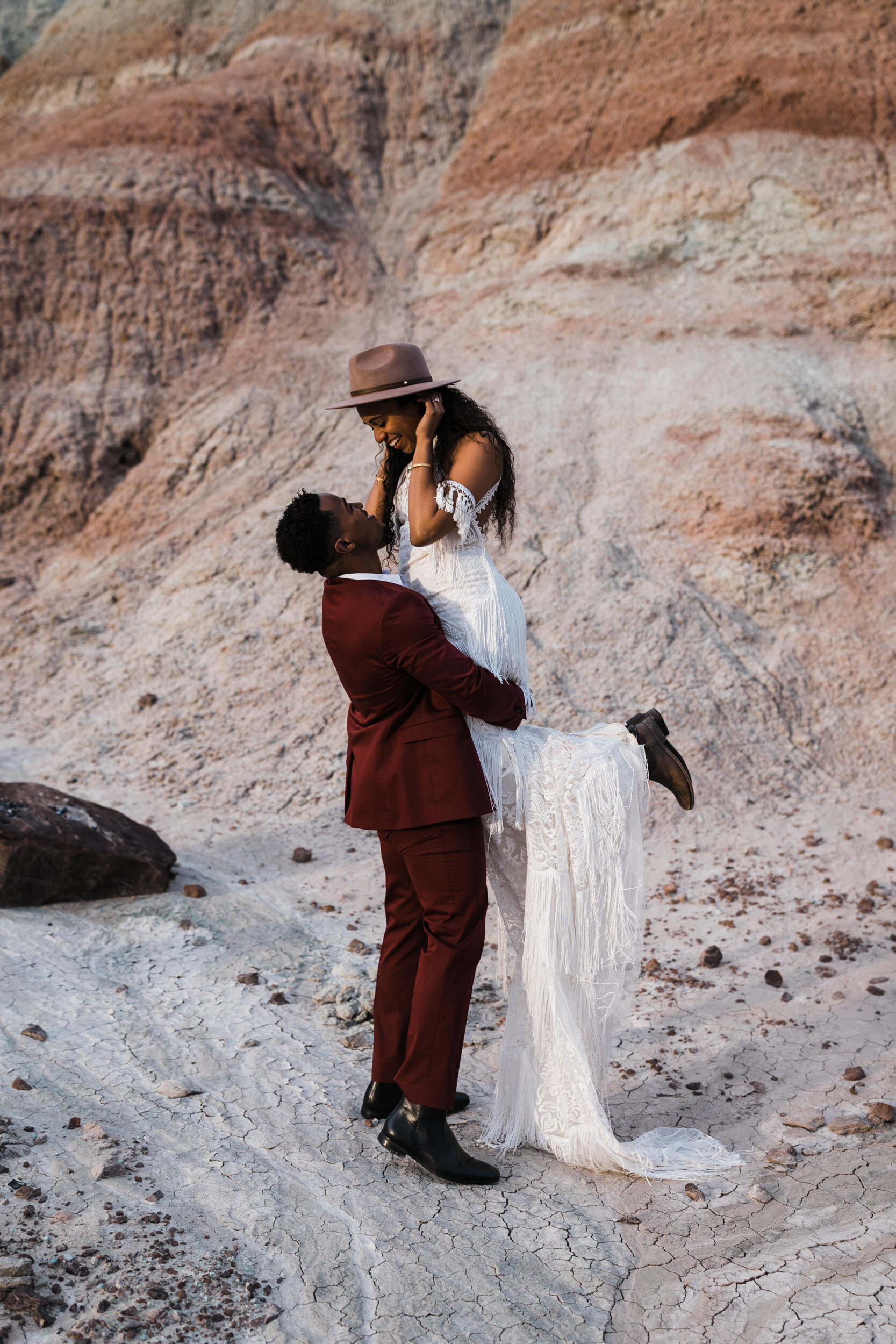 Moab Elopement Photographer | The Hearnes | Rue de Seine Dallas Gown | Bohemian Bride Fringe Wedding Dress &amp; Groom’s Burgundy Suit