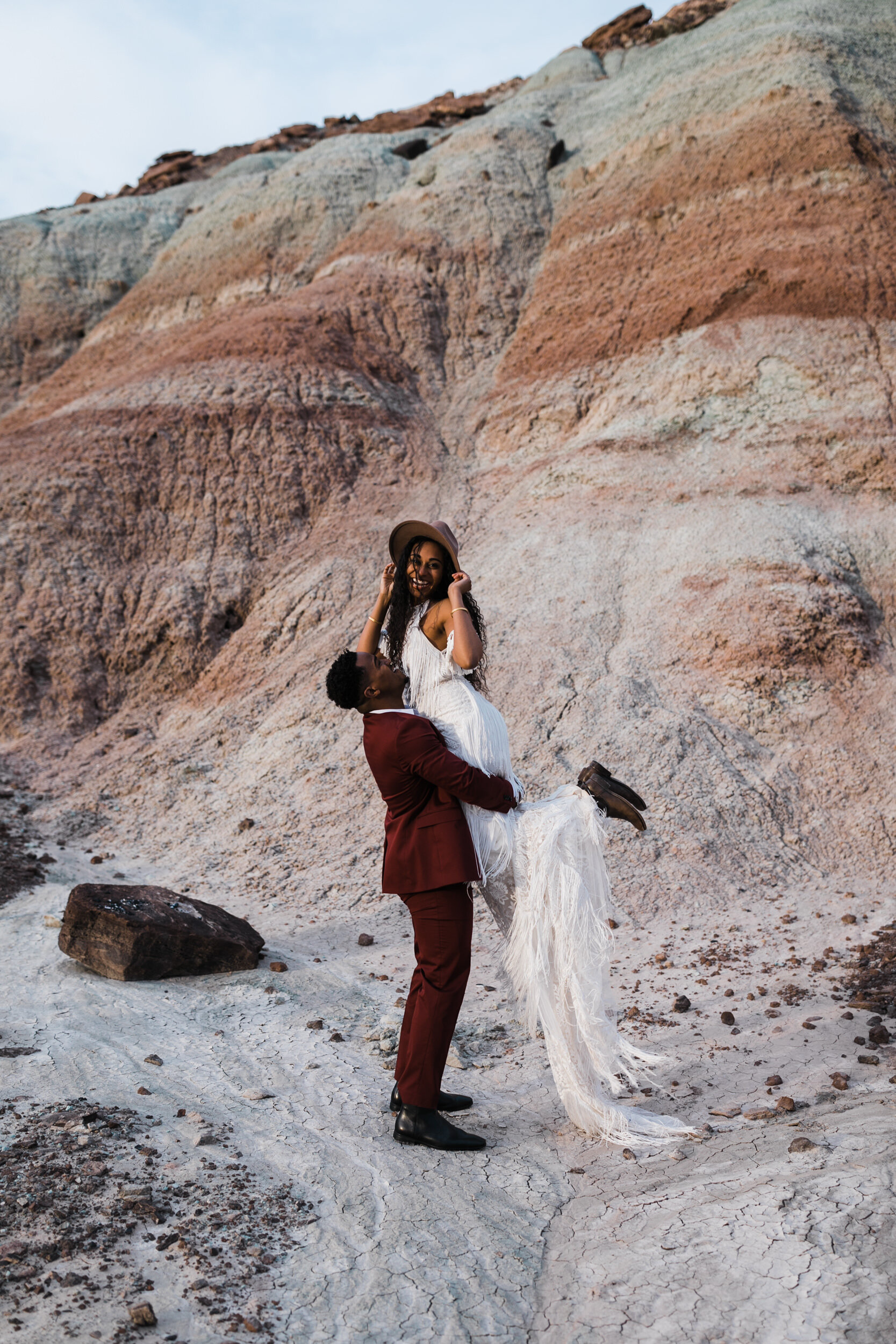 Moab Elopement Photographer | The Hearnes | Rue de Seine Dallas Gown | Bohemian Bride Fringe Wedding Dress &amp; Groom’s Burgundy Suit