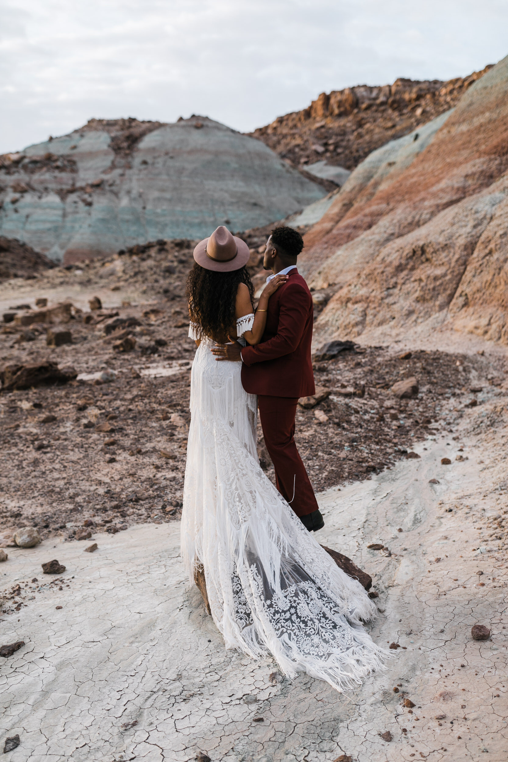 Moab Elopement Photographer | The Hearnes | Rue de Seine Dallas Gown | Bohemian Bride Fringe Wedding Dress &amp; Groom’s Burgundy Suit