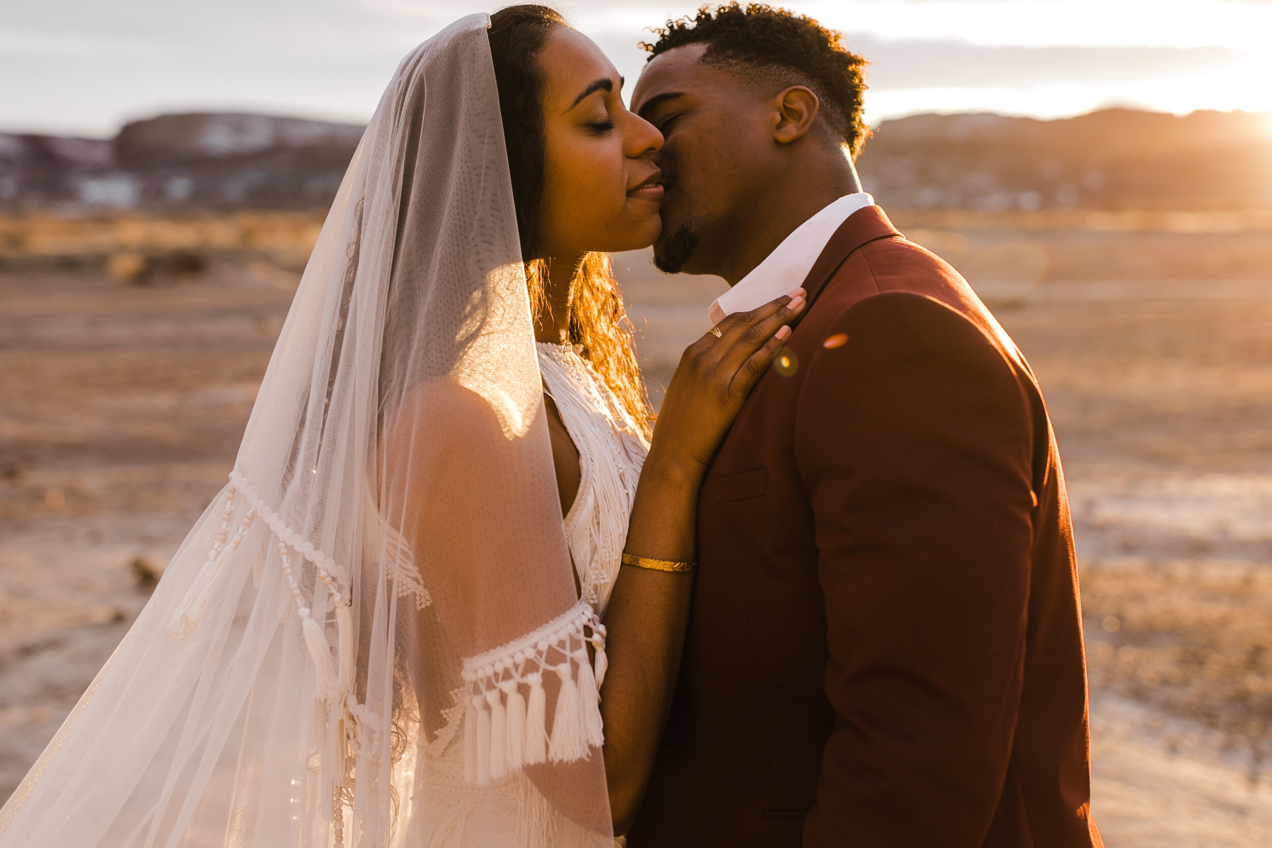 Moab Elopement Photographer | The Hearnes | Rue de Seine Dallas Gown | Bohemian Bride Fringe Wedding Dress &amp; Groom’s Burgundy Suit