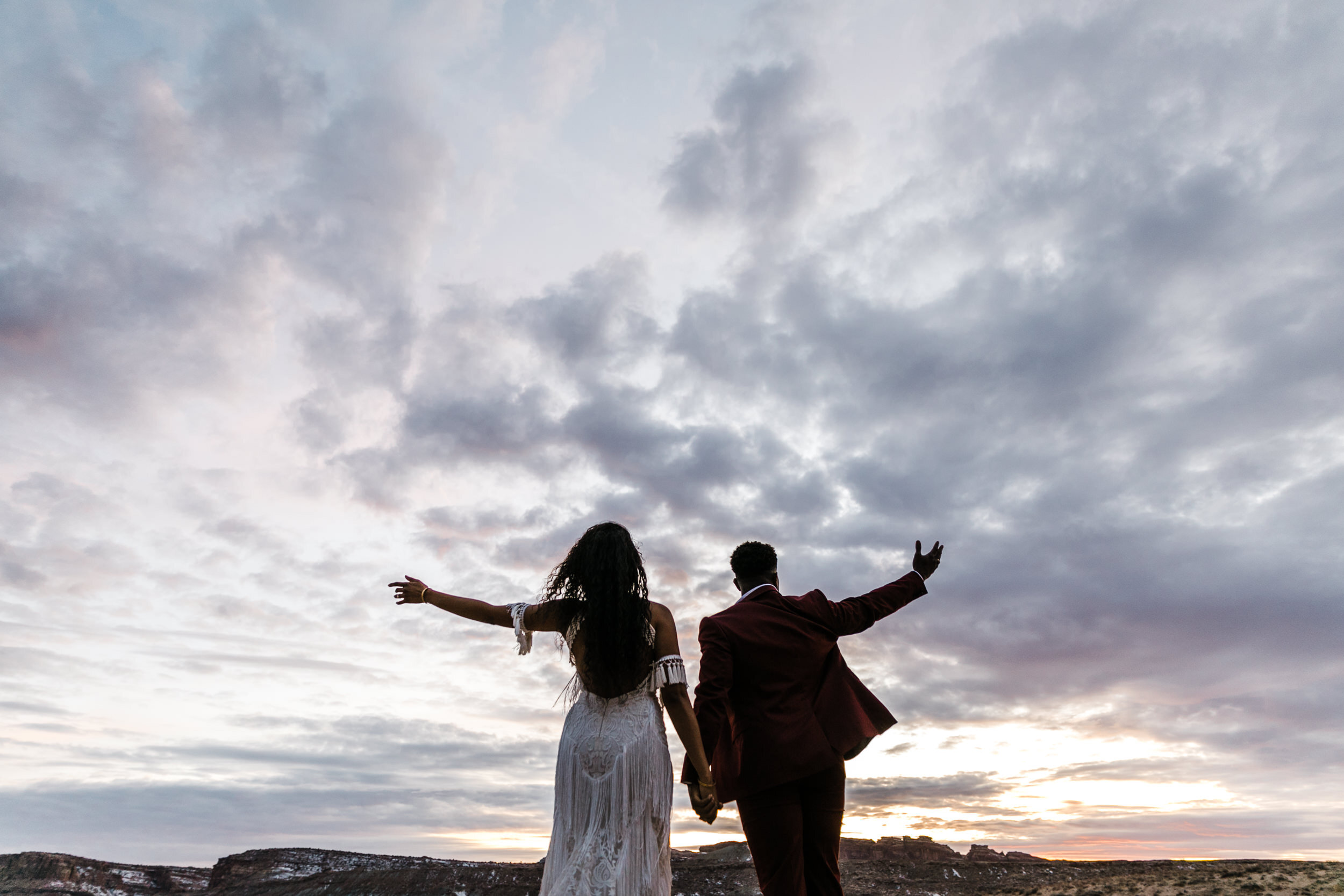 Moab Elopement Photographer | The Hearnes | Rue de Seine Dallas Gown | Bohemian Bride Fringe Wedding Dress &amp; Groom’s Burgundy Suit