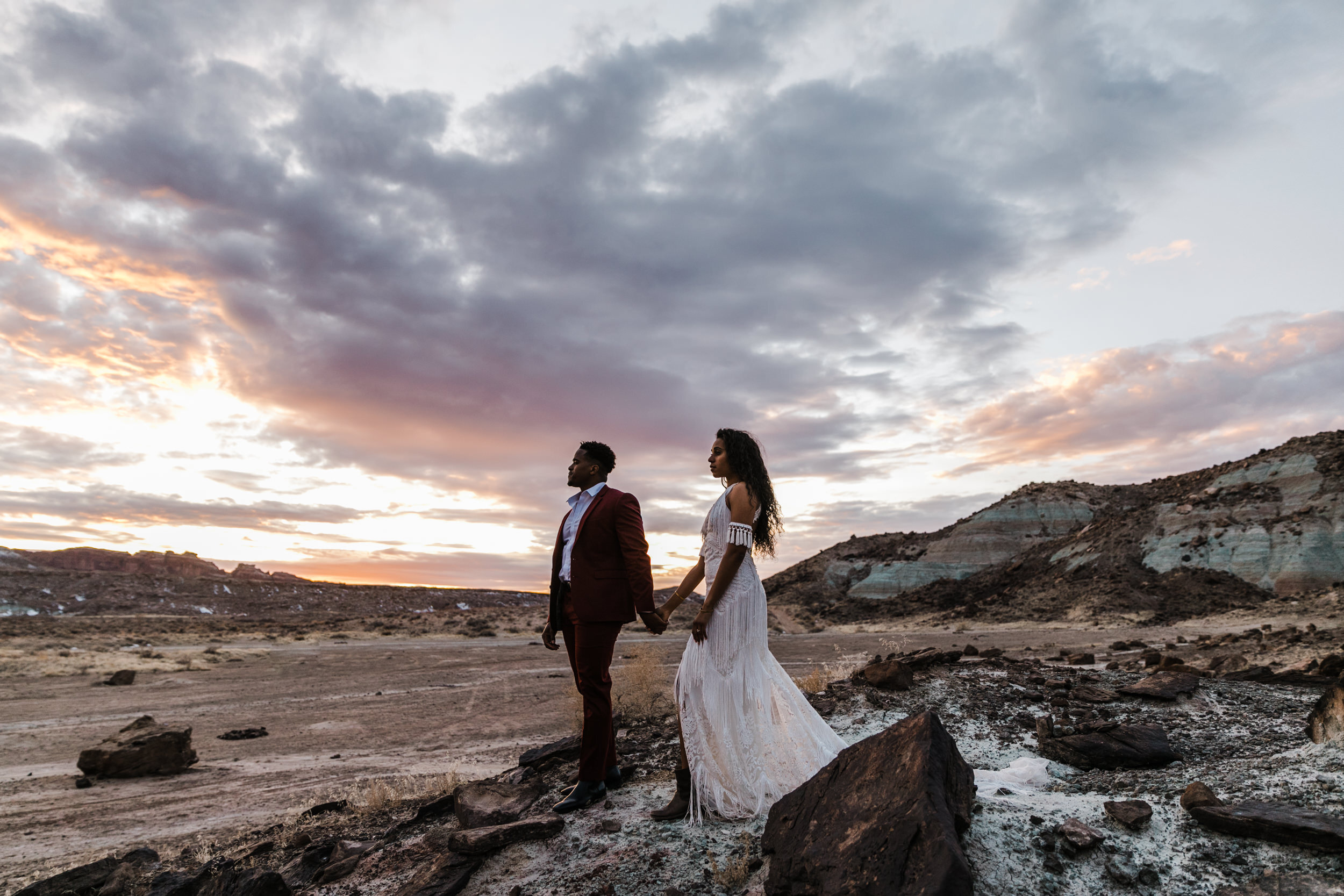 Moab Elopement Photographer | The Hearnes | Rue de Seine Dallas Gown | Bohemian Bride Fringe Wedding Dress &amp; Groom’s Burgundy Suit