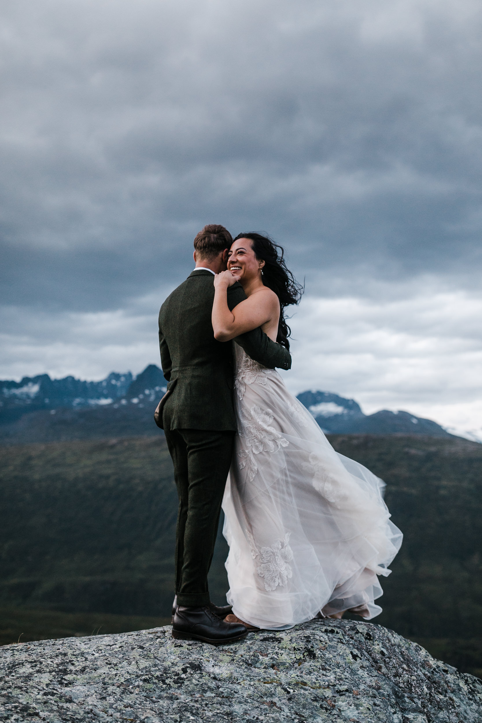 mountain top elopement in alaska | blush colored wedding dress | dark green groom suit | the hearnes adventure photography