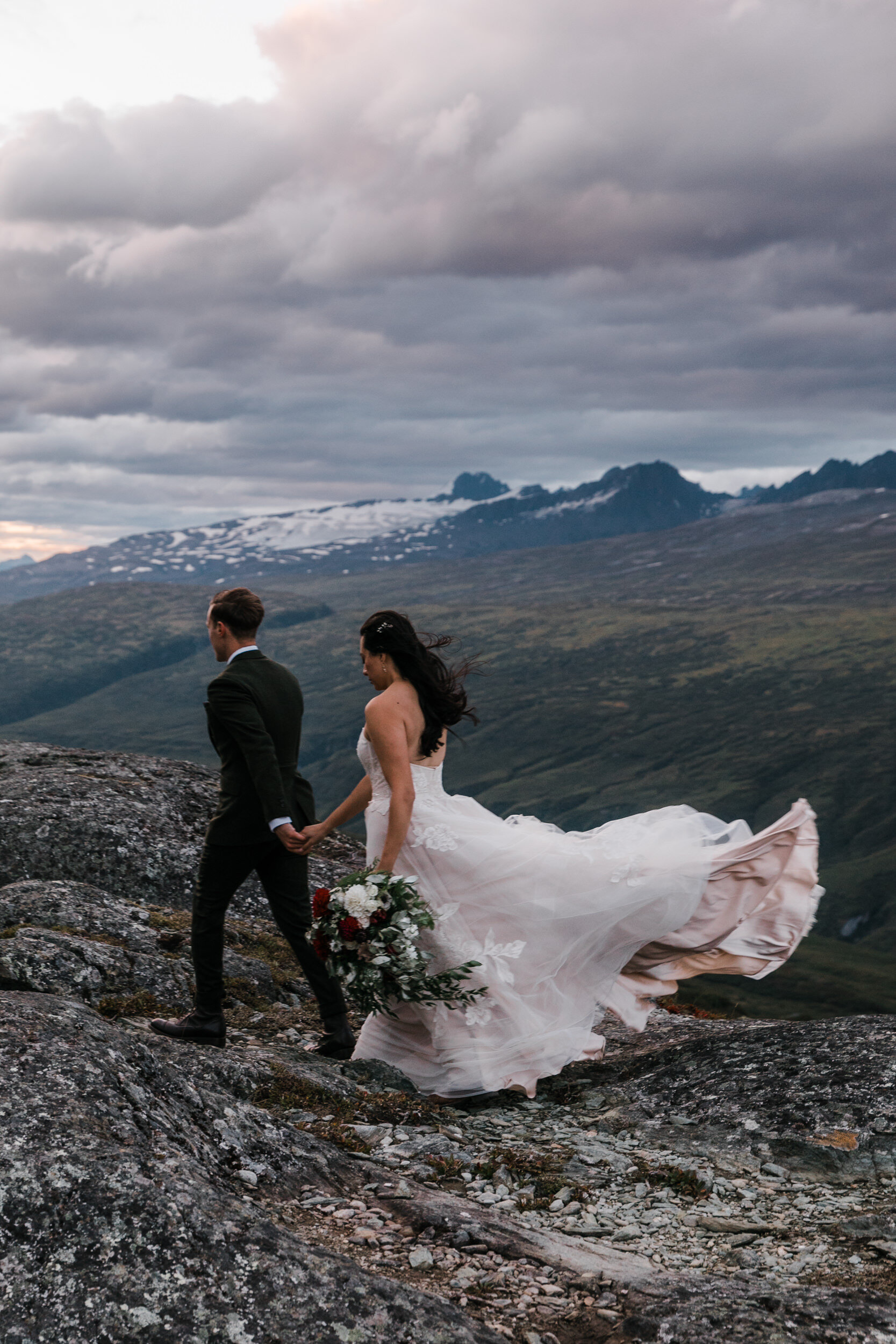 mountain top elopement in alaska | blush colored wedding dress | dark green groom suit | the hearnes adventure photography