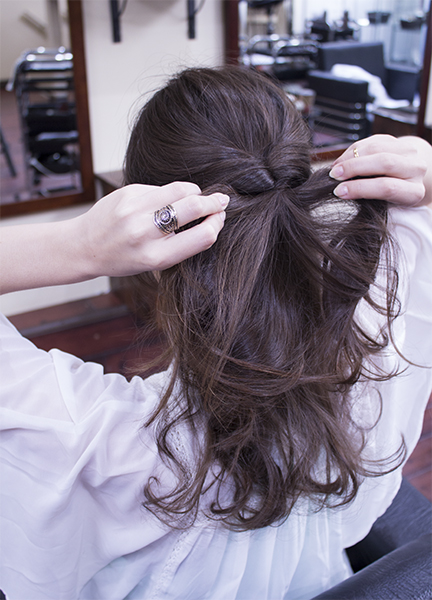 2) Take the top knot and place your fingers and the middle. Spread the knot by pulling left and right to create a hole. Now lift the pony tail and pull through the hole you just made. We call this a "kururin-pa" in Japanese. 3) Tug under the knot left and right to tighten and lift the band.