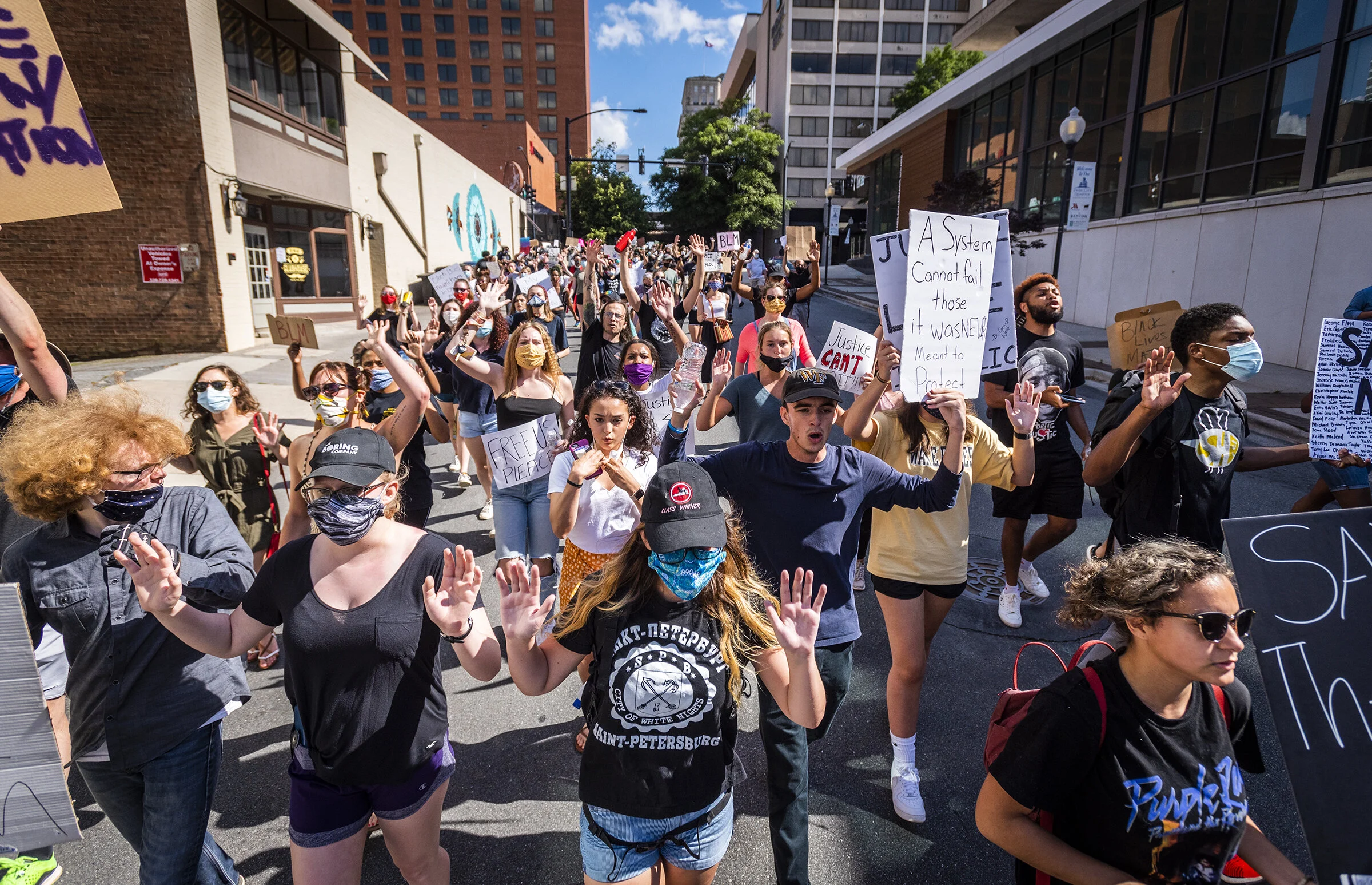  Demonstrators participate in a Black Lives Matter march down Cherry Street after a rally at Bailey Park on Sunday, May 31, 2020 in Winston-Salem, N.C.  