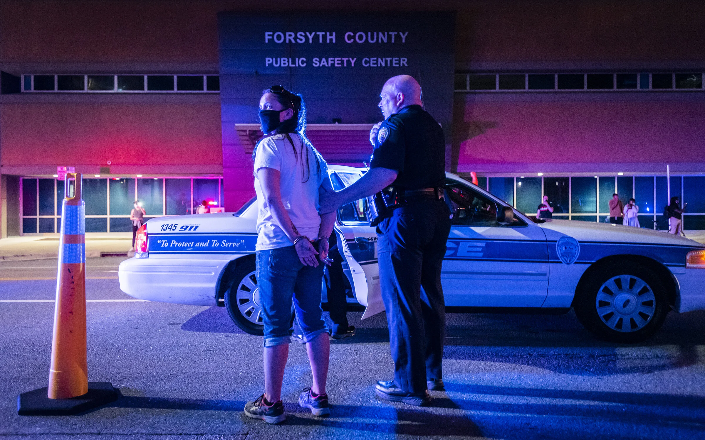  A demonstrator is arrested by an officer with the Winston-Salem Police Department during a protest over the death of John Neville in front of the Forsyth County Sheriff's Office on Thursday, July 9, 2020 in Winston-Salem, N.C. 