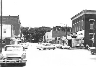 The store is on the near right hand side of the street.