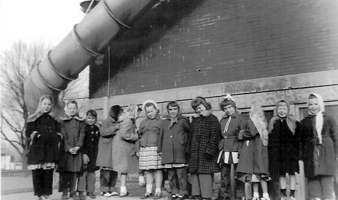 Second Grade girls, Winter 1954-1955 standing on concrete wall of sandbox. Note the metal fire escape tube. L-R: Martha Monroe, Sherry Faidley, Sharon Mallory, Beth Barrett, Terri Smith, Ann Cashman, Marilyn Brown, Carolyn Zachary, Kathleen Hunter, Cathy Webb, Kay Purcell, Linda Stewart