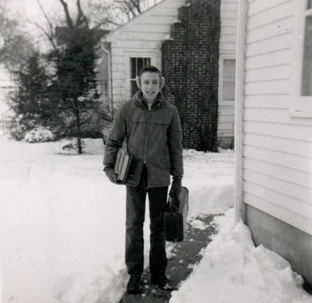 Classic picture of me with earmuffs, load of books in one arm and horn case in the other. Undated photo from next to house on South Locust.