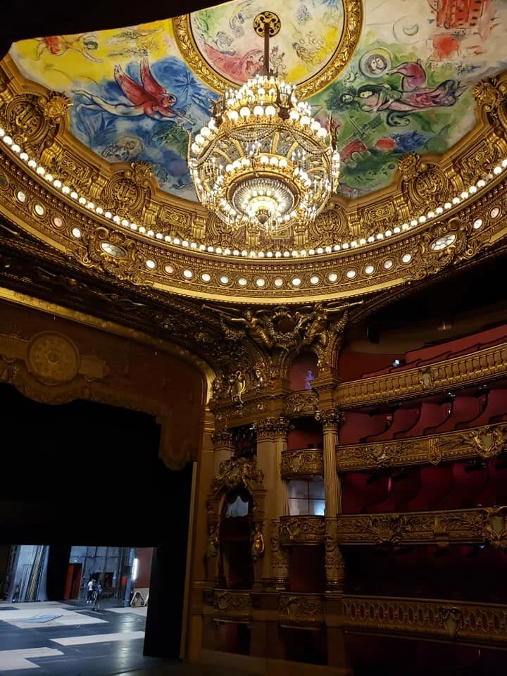 Inside the theater itself. The chandelier weighs 7 tons. The ceiling area which surrounds the chandelier was originally painted by Jules Eugène Lenepveu. In 1964 a new ceiling painted by Marc Chagall was installed on a removable frame over the original. It depicts scenes from operas by 14 composers.