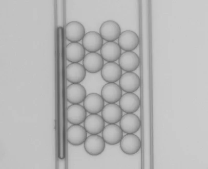 Compressing soft colloidal aggregates: perfect 2D crystal with one defect
