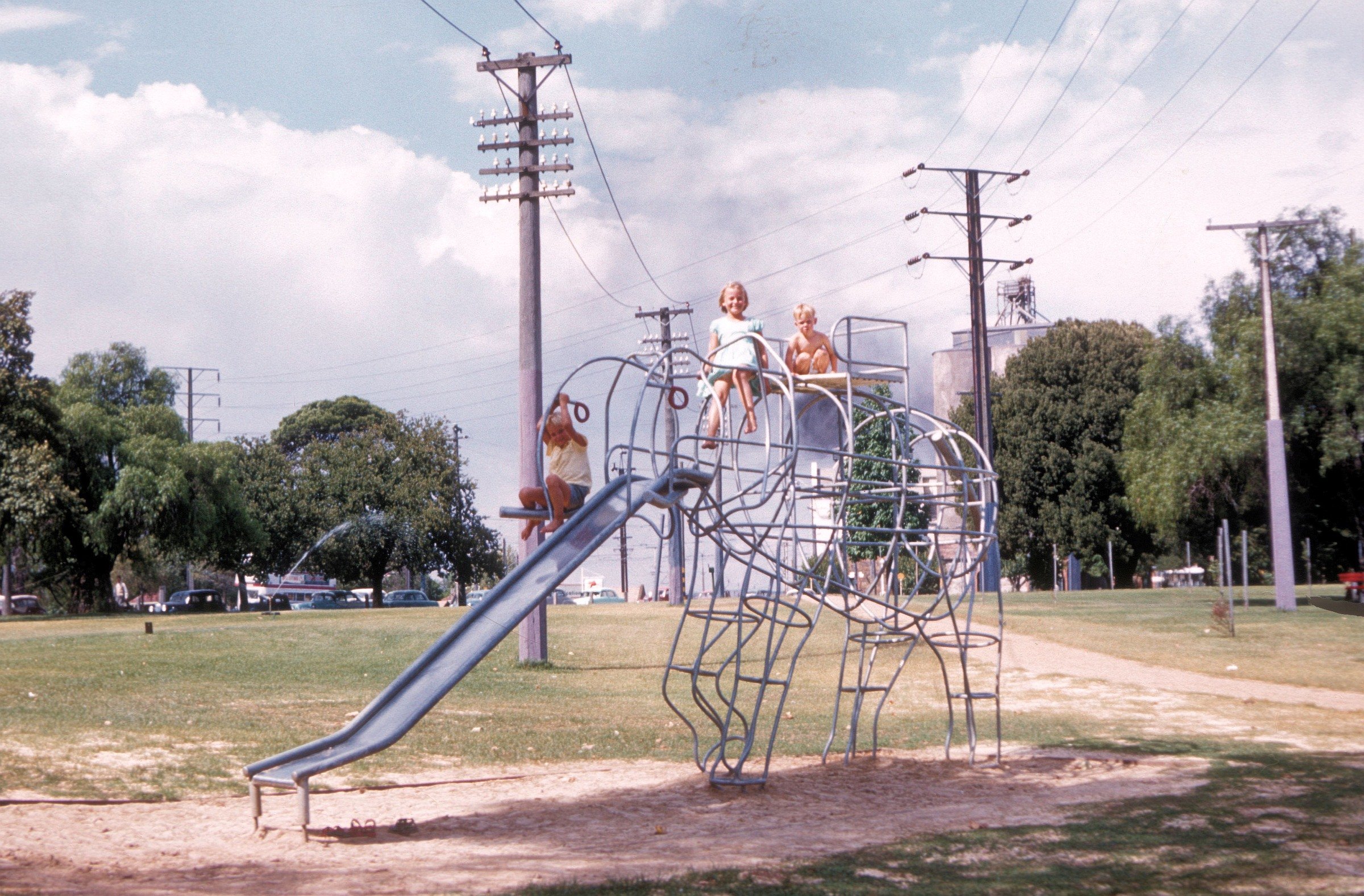 John, Dianne and Barry Christiansen enjoying the brand new elephant climbing frame in Rymill Park, early 1961