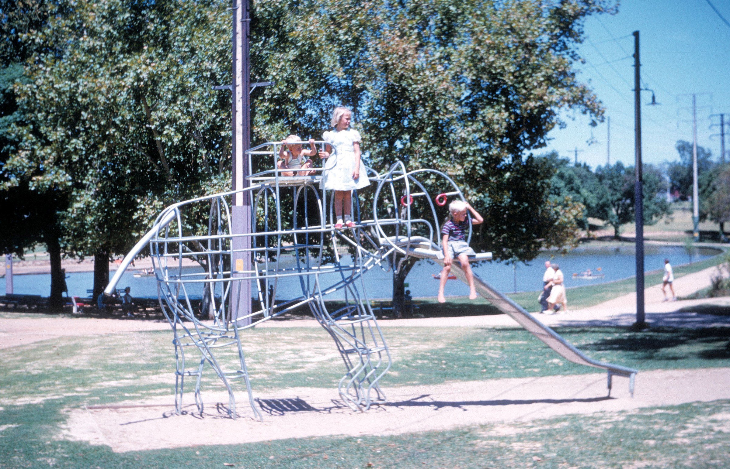 John, Dianne and Barry Christiansen enjoying the brand new elephant climbing frame in Rymill Park, early 1961