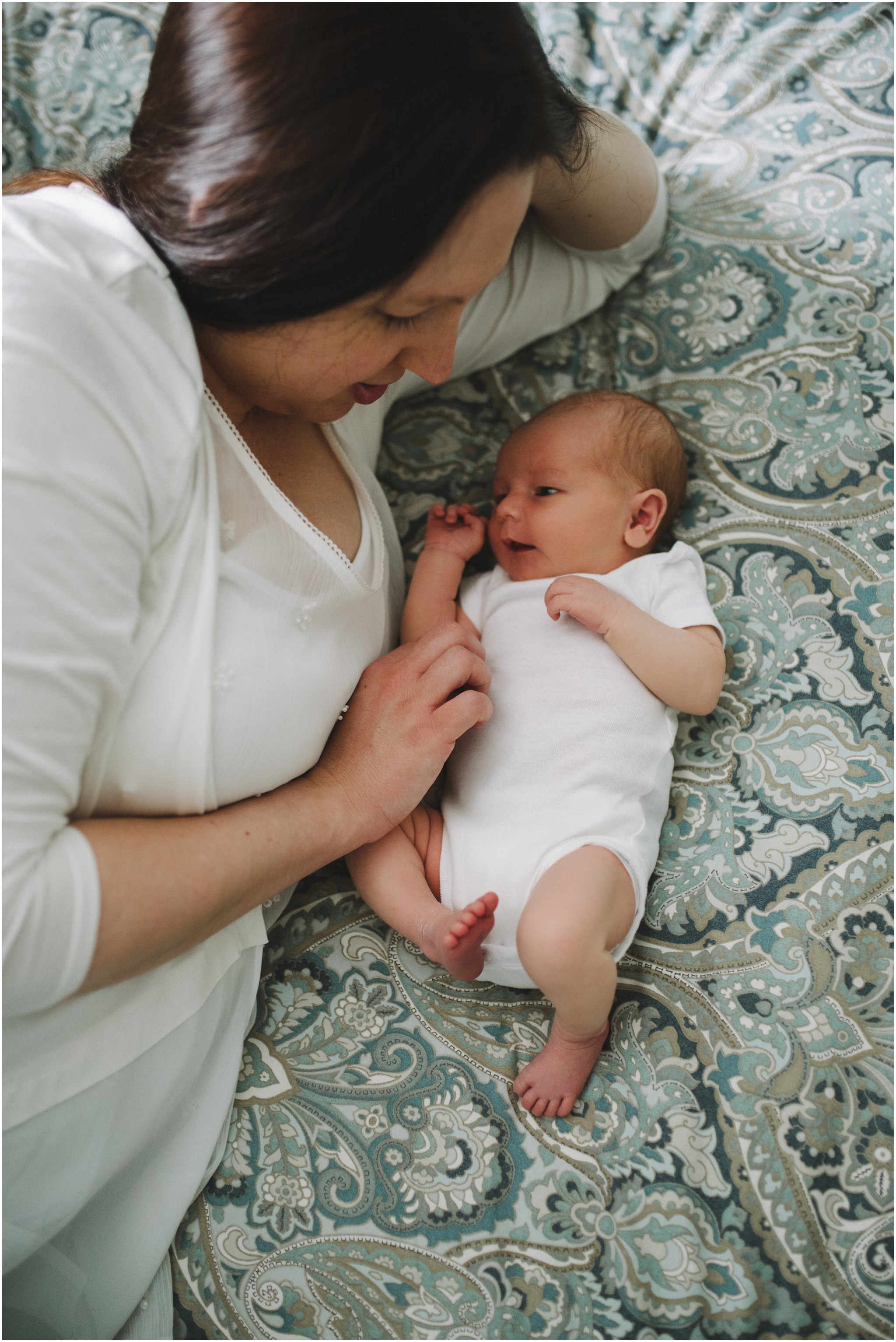 mom and baby laying on the bed
