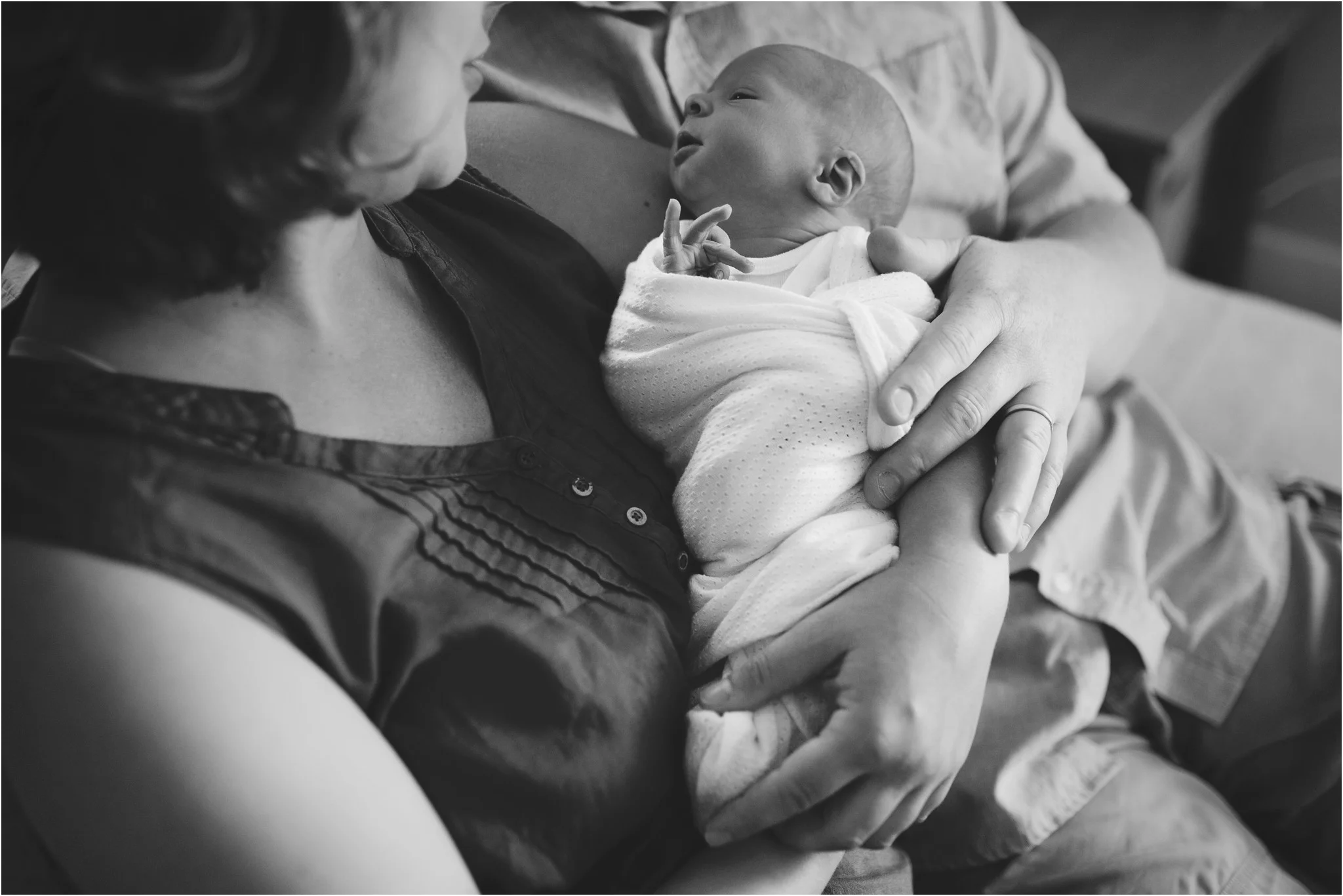 mom and dad touching baby