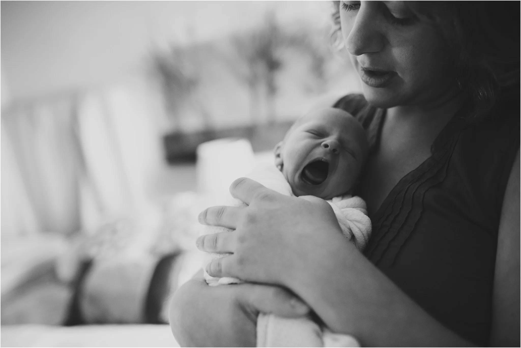 mom holding baby yawning
