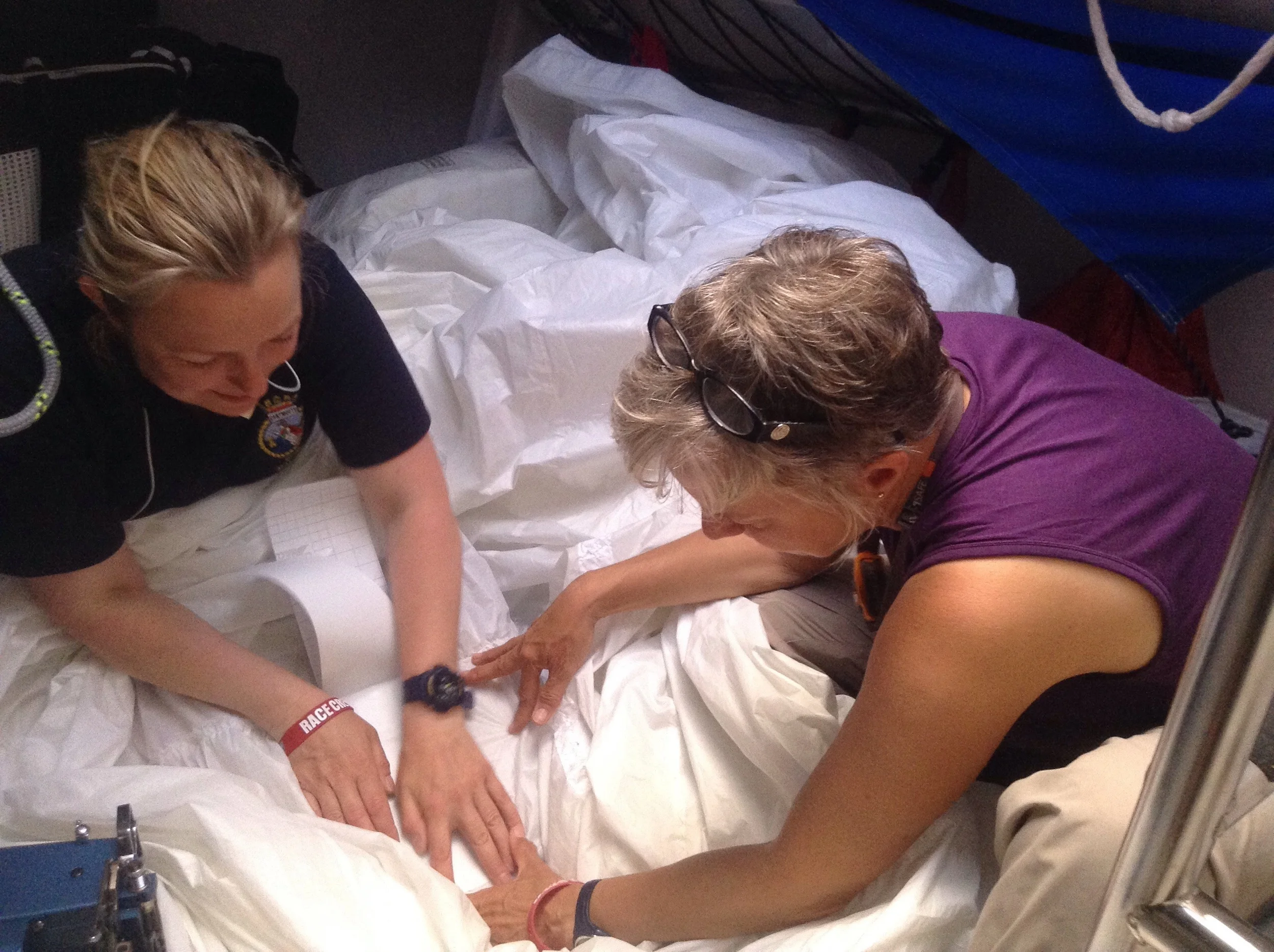 Lynn helps Jane stick on sail patches to be sewn. 