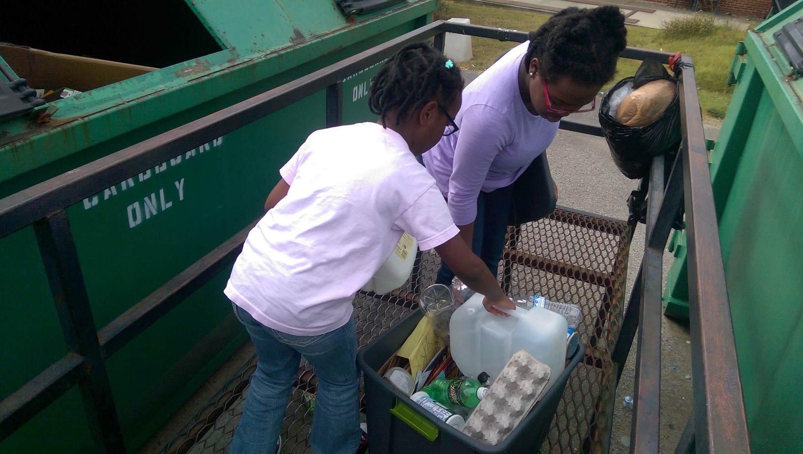 Placing all the plastic into the plastic receptacle at the recycling center.