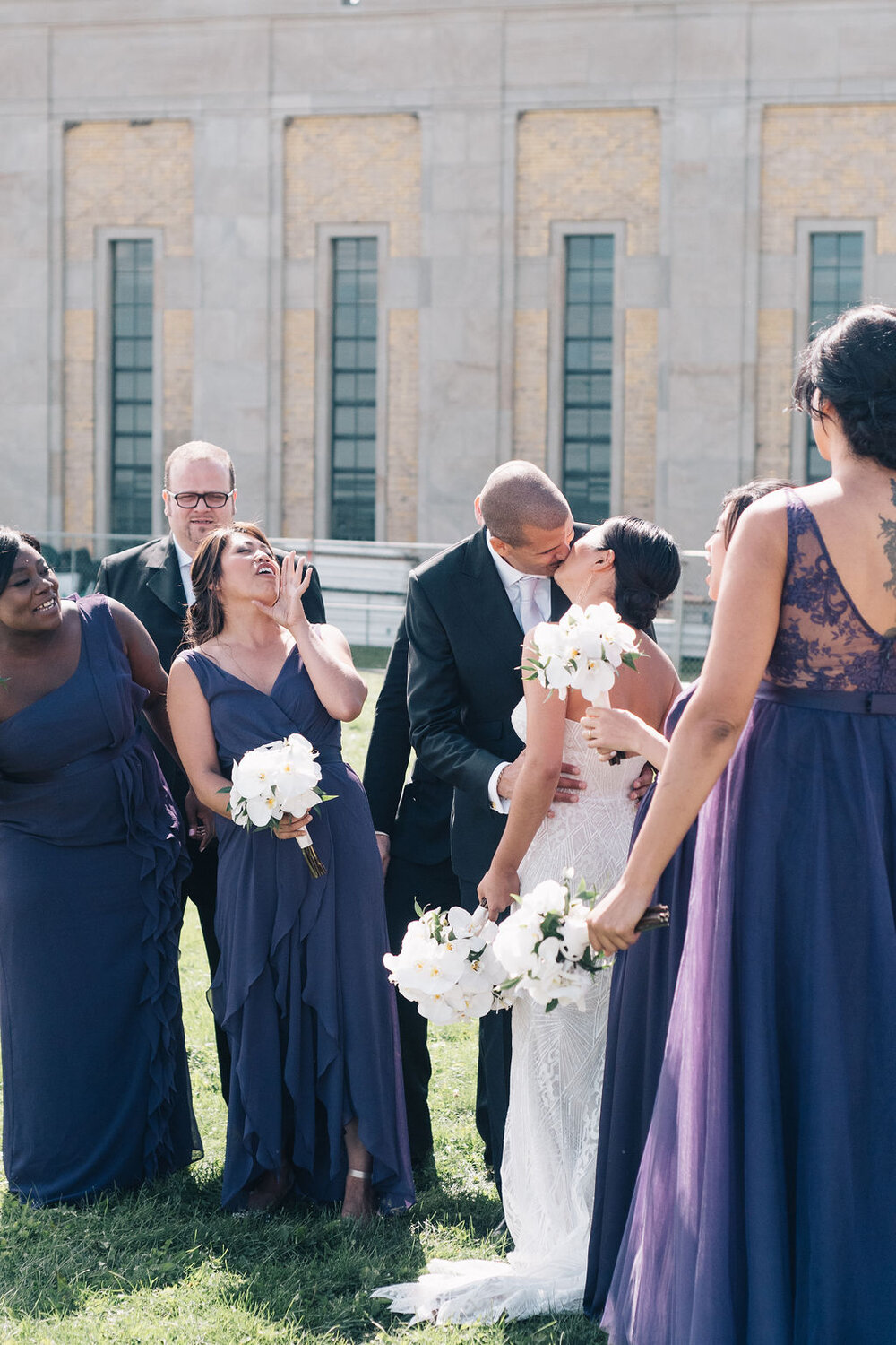 Toronto bride and groom kiss as bridal party cheers them on!