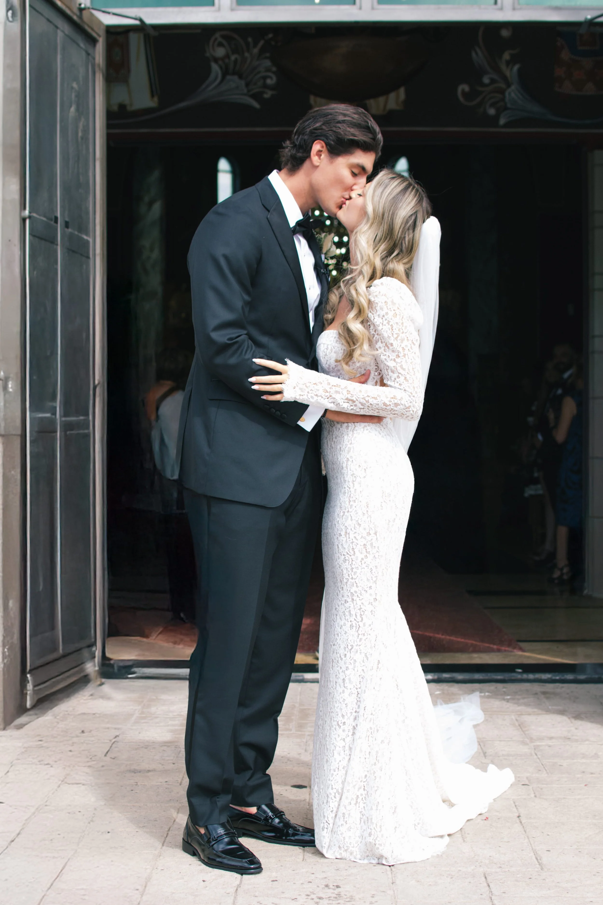 bride-groom-kissing-outside-wedding-ceremony