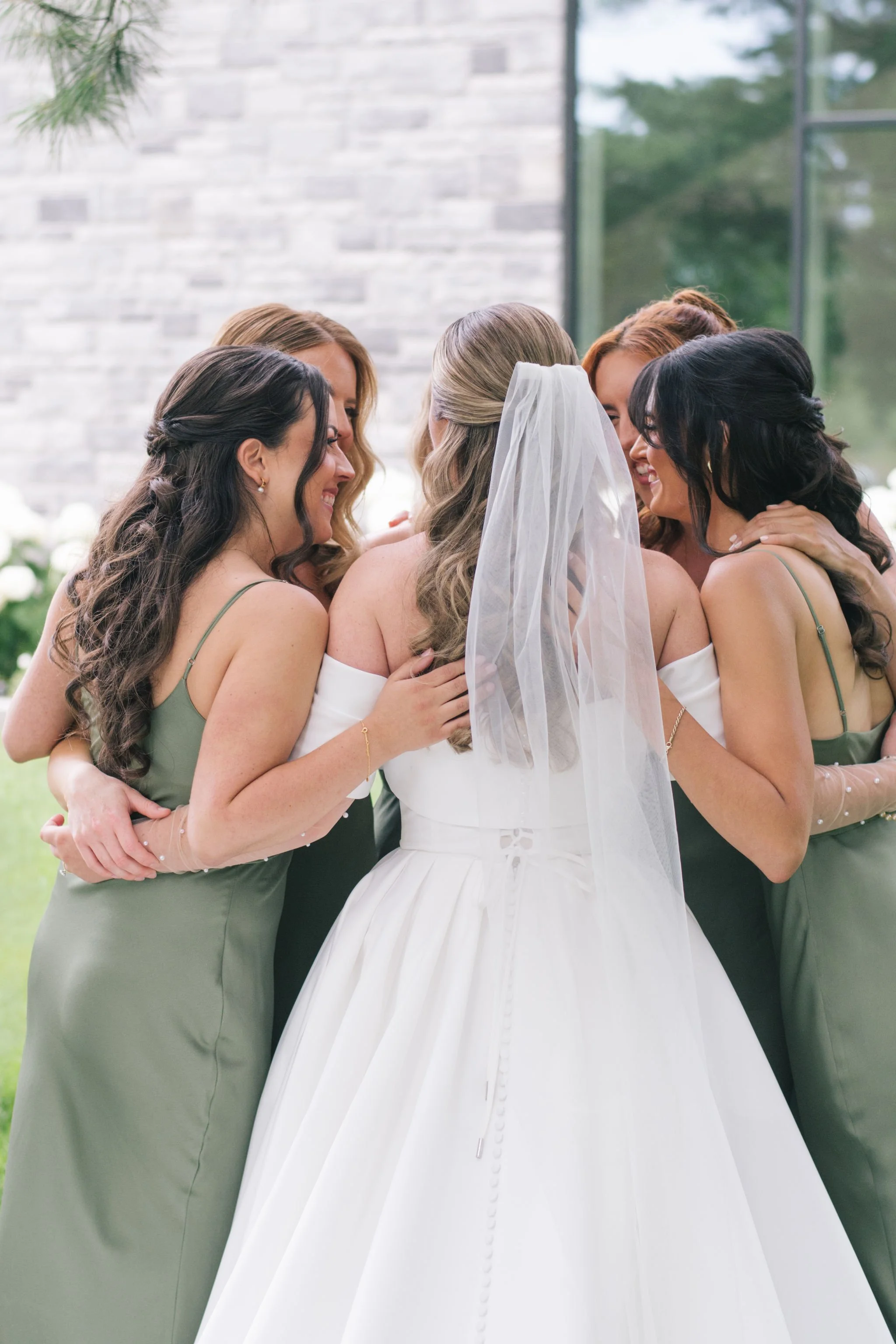 bride-and-bridesmaids-group-hug-three-feathers-terrace