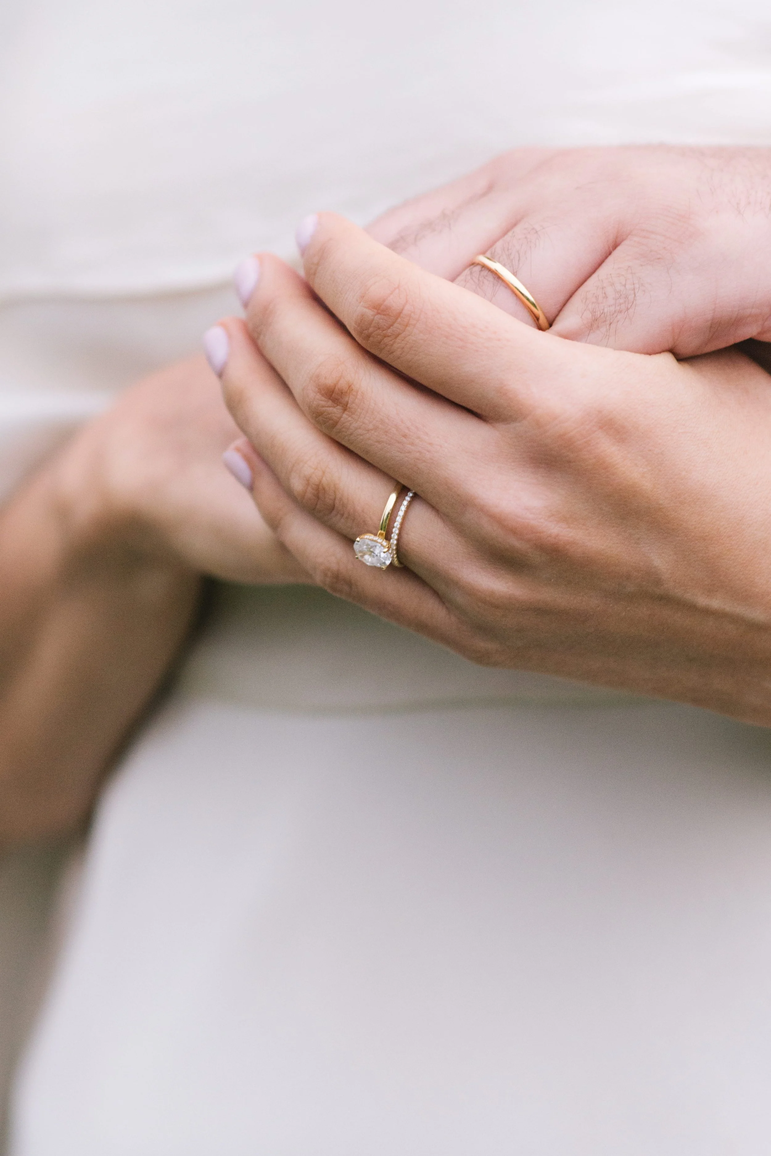 Minimalist wedding ring detail shot featuring a round-cut diamond Cartier engagement ring and yellow gold Cartier bands, captured by a Toronto luxury wedding photographer.