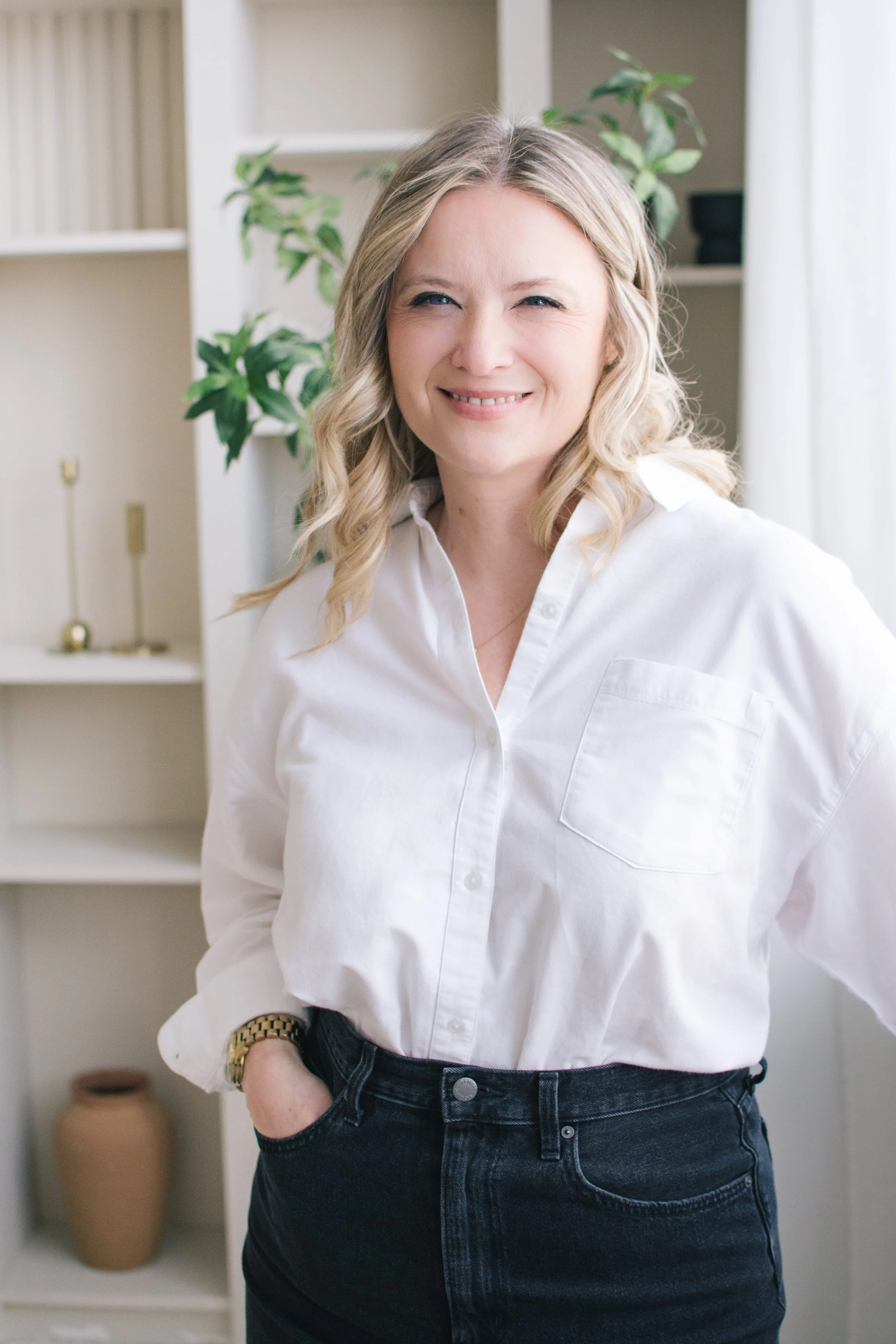 Female wedding photographer smiling during her brand portrait in a bright studio setting