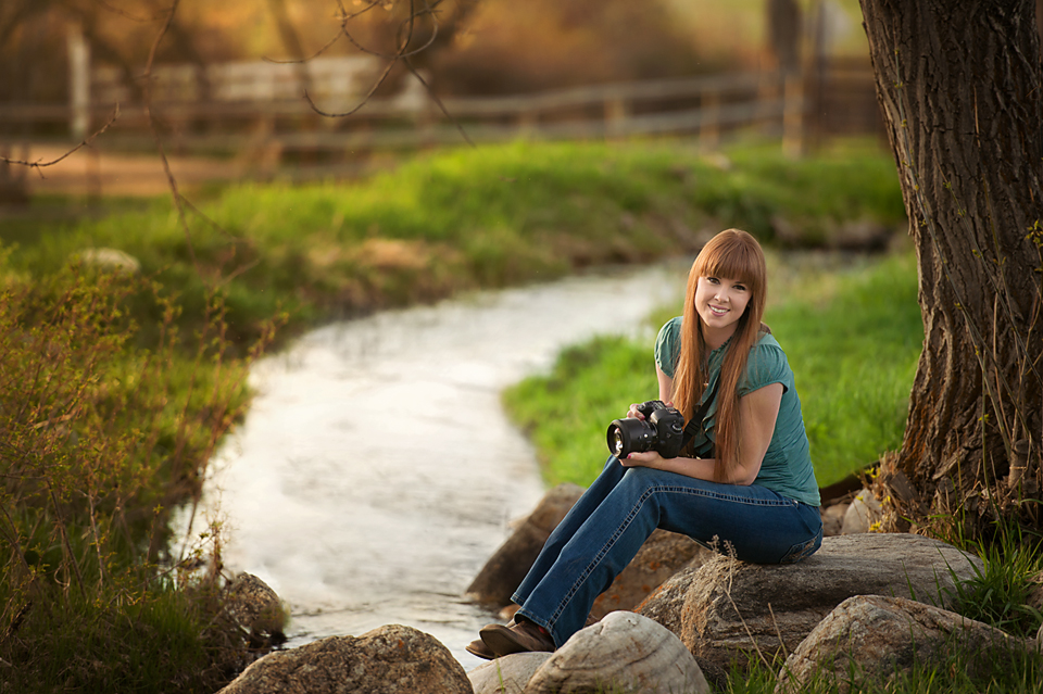 woman by stream with camera