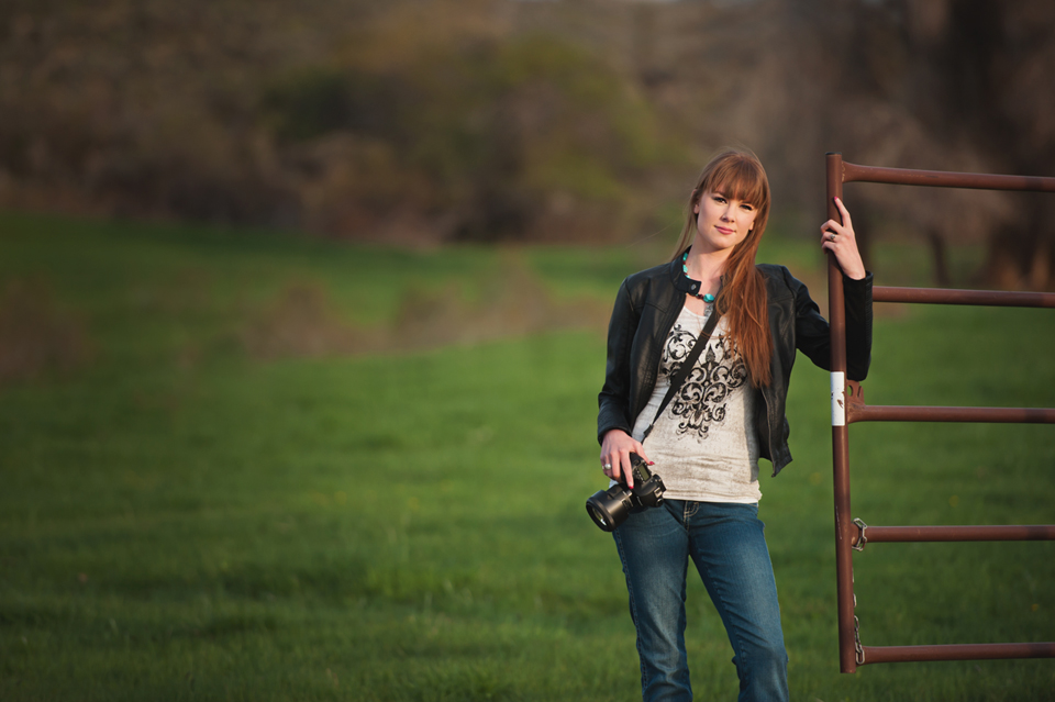 woman photographer leaning on fence