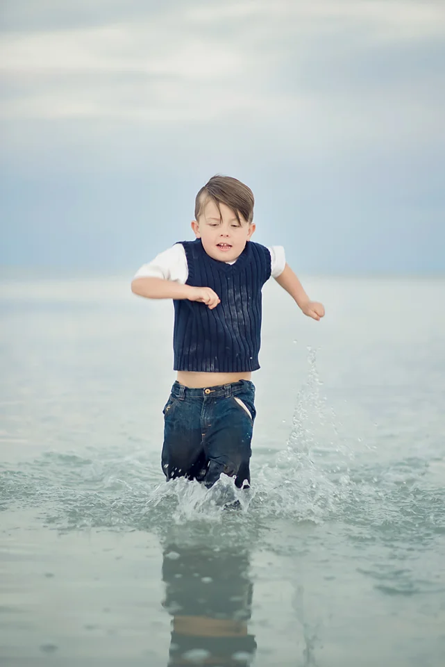 boy running through shallow water