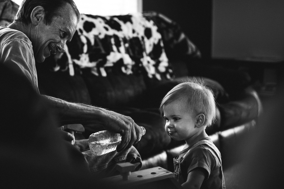 grandpa and granddaughter playing with water bottle